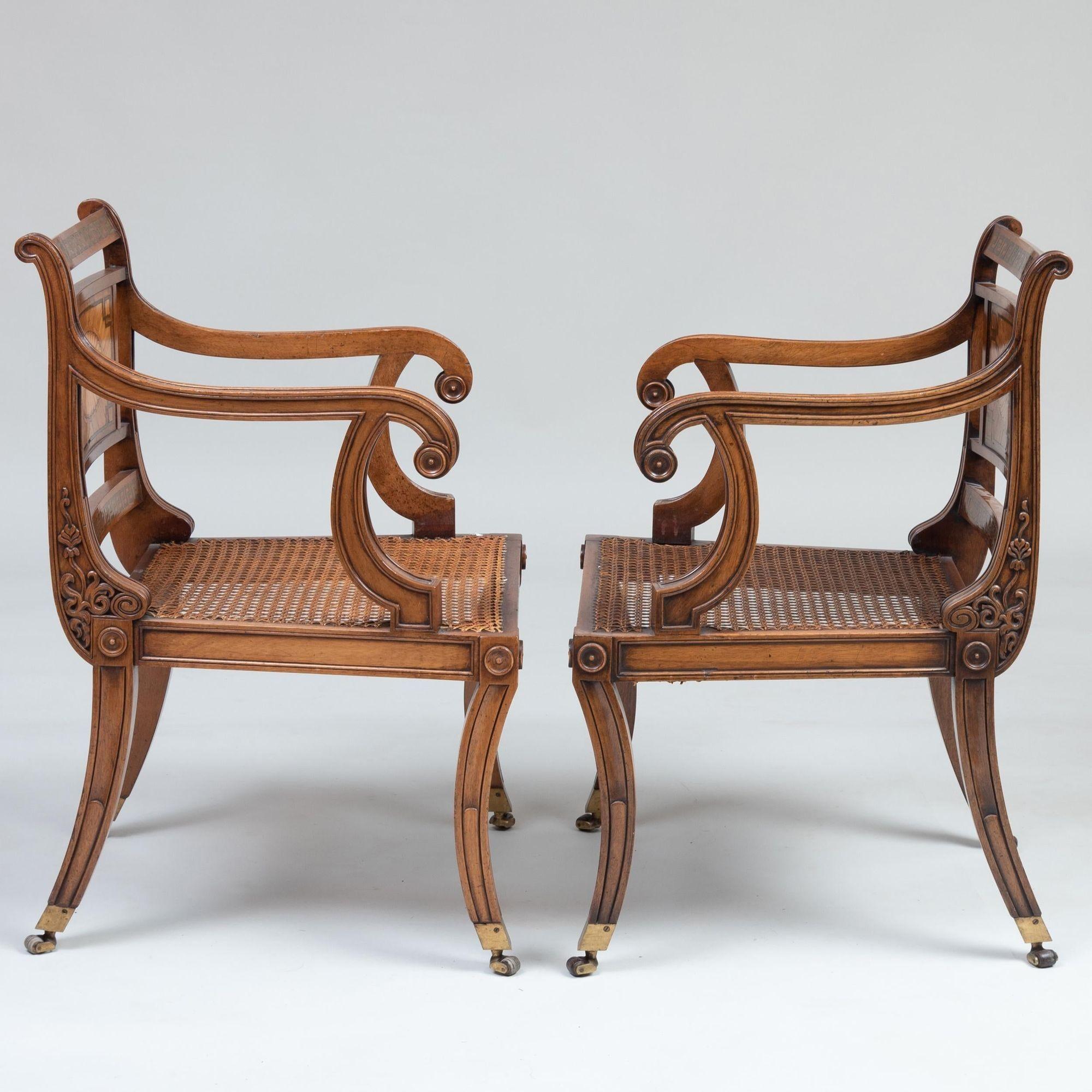 Remarkable set of 10 Regency style brass inlaid mahogany chairs with rosewood, satinwood and kingwood veneers, having paterae inlaid back panels over caned seats with leather upholstered squab cushions, standing on saber legs ending in box casters.