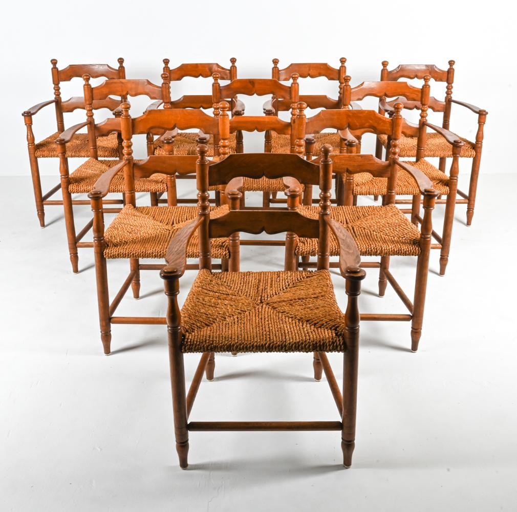 Add rustic charm to your dining room with this classic set of (10) armchairs in the style of Charles Dudouyt, constructed from rich and warm solid oak wood, with seats woven from oversized ropes of papercord rush. The frames feature interesting