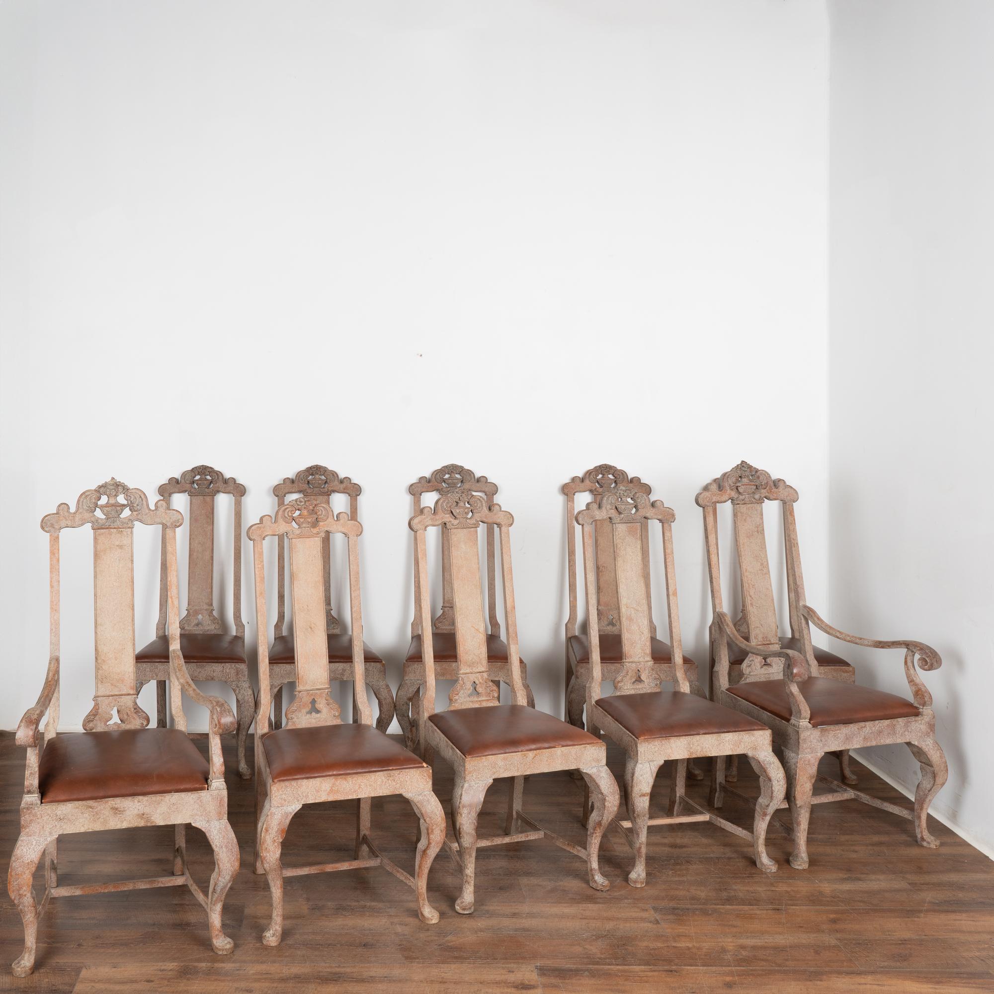 Antique set of ten Swedish country baroque dining chairs with tall backs, eight side chairs and two arm chairs included. 
Note the exceptional antique white painted and rubbed out finish, creating a rich, deep look with the natural oak revealed