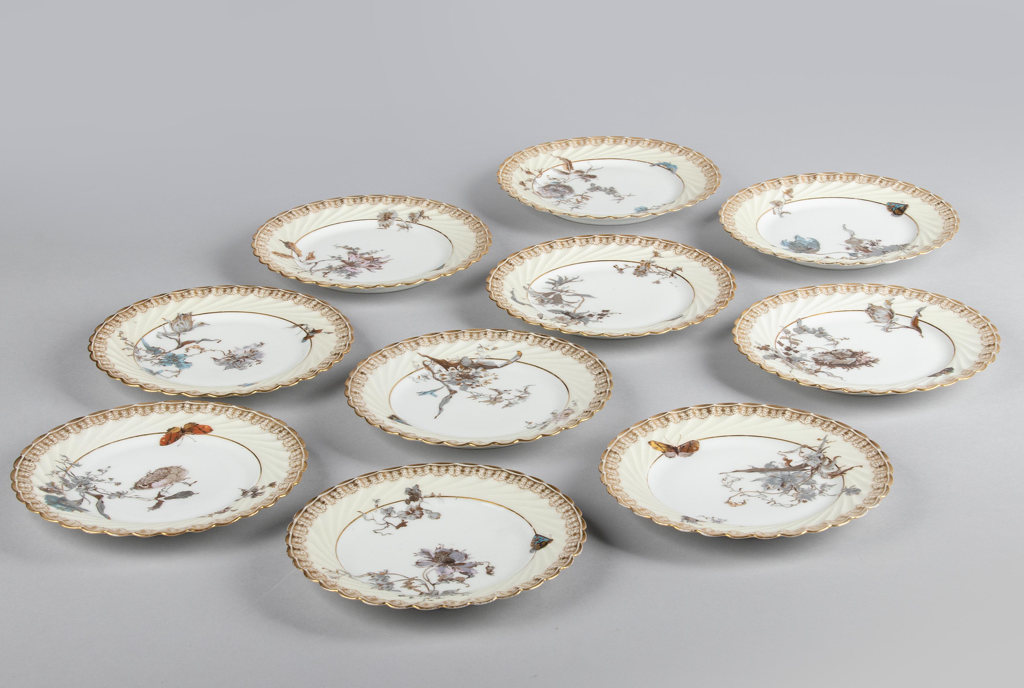 Beautiful set of 10 porcelain cake plates from the French brand Haviland Limoges. The plates have curved edges and are richly decorated with various images of flowers, butterflies and gold-coloured accents. The porcelain dates from around