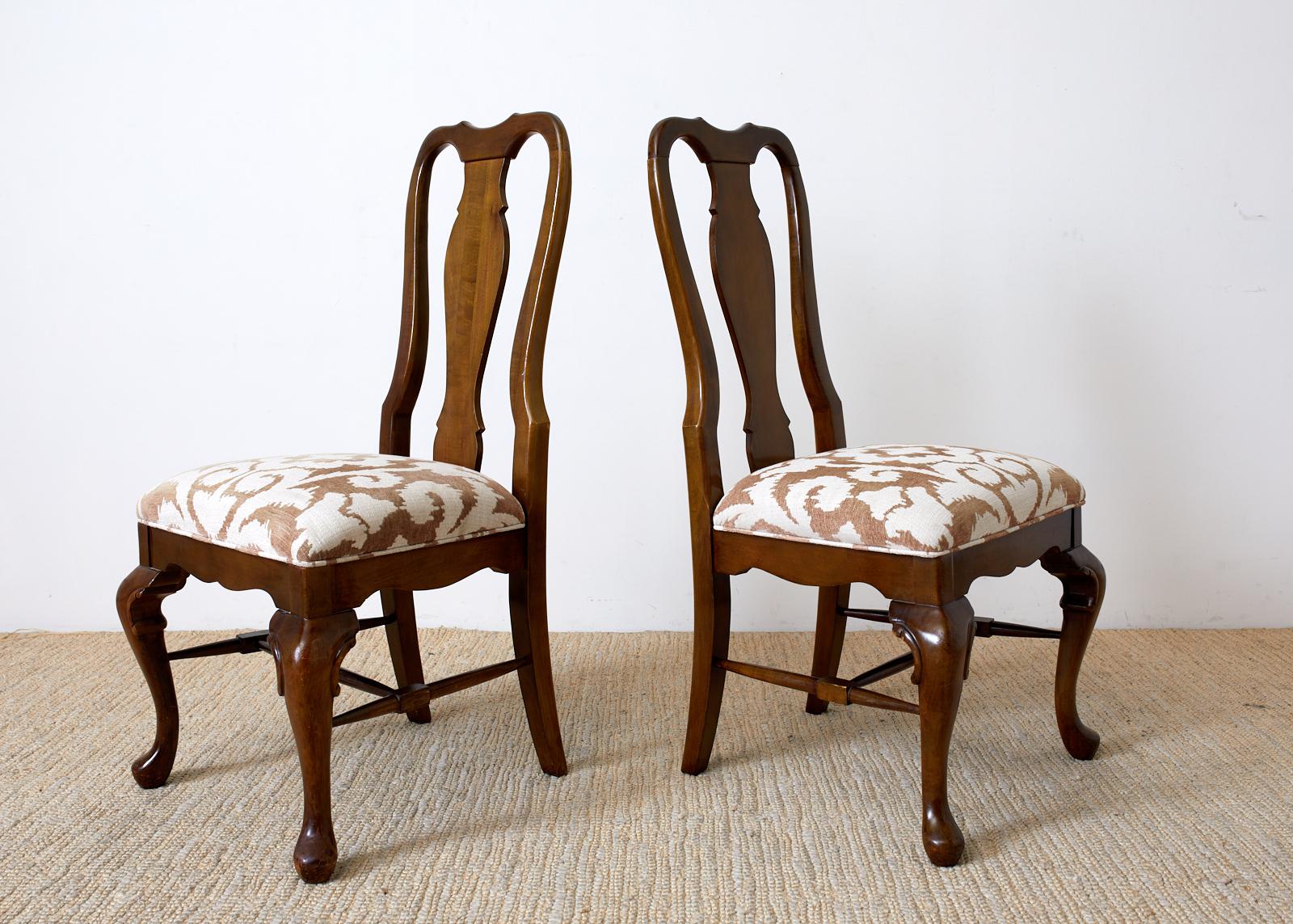 Handsome set of ten mahogany dining chairs made in the Queen Anne taste. Features a tall shaped back having a vasiform splat with an upholstered seat. Modern floral motif print on linen style fabric seat. Supported by cabriole legs in front ending