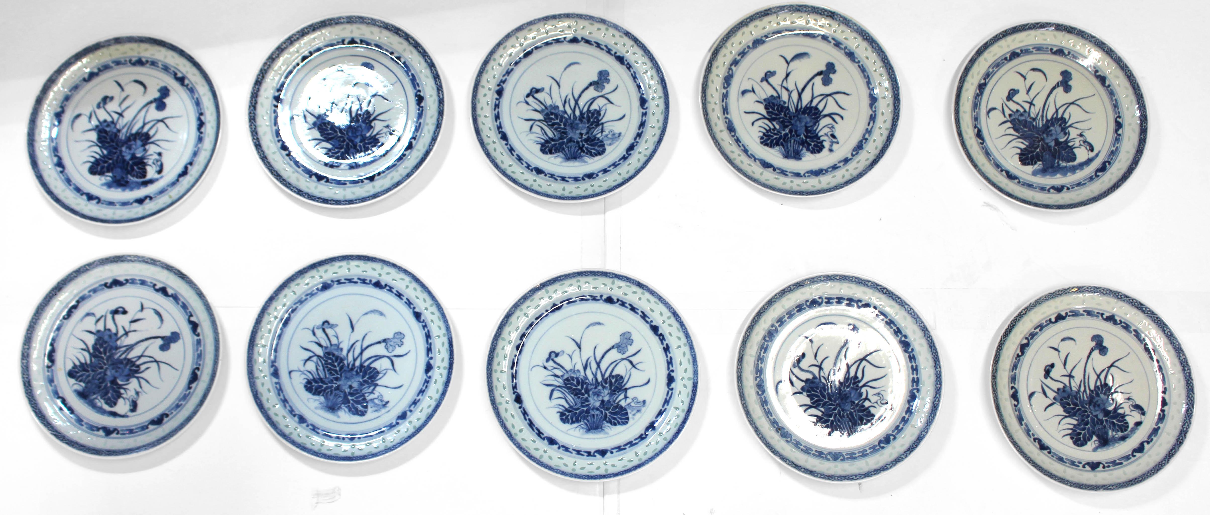 Set of 10 Rice Ware Dinner Plates, Chinese export, circa 1900-1925. For 7 the central decoration features an Egret by an abundance of flora at water's edge and for 3 there is a duck by the flora. Diamond geometric border, inner border with bats for