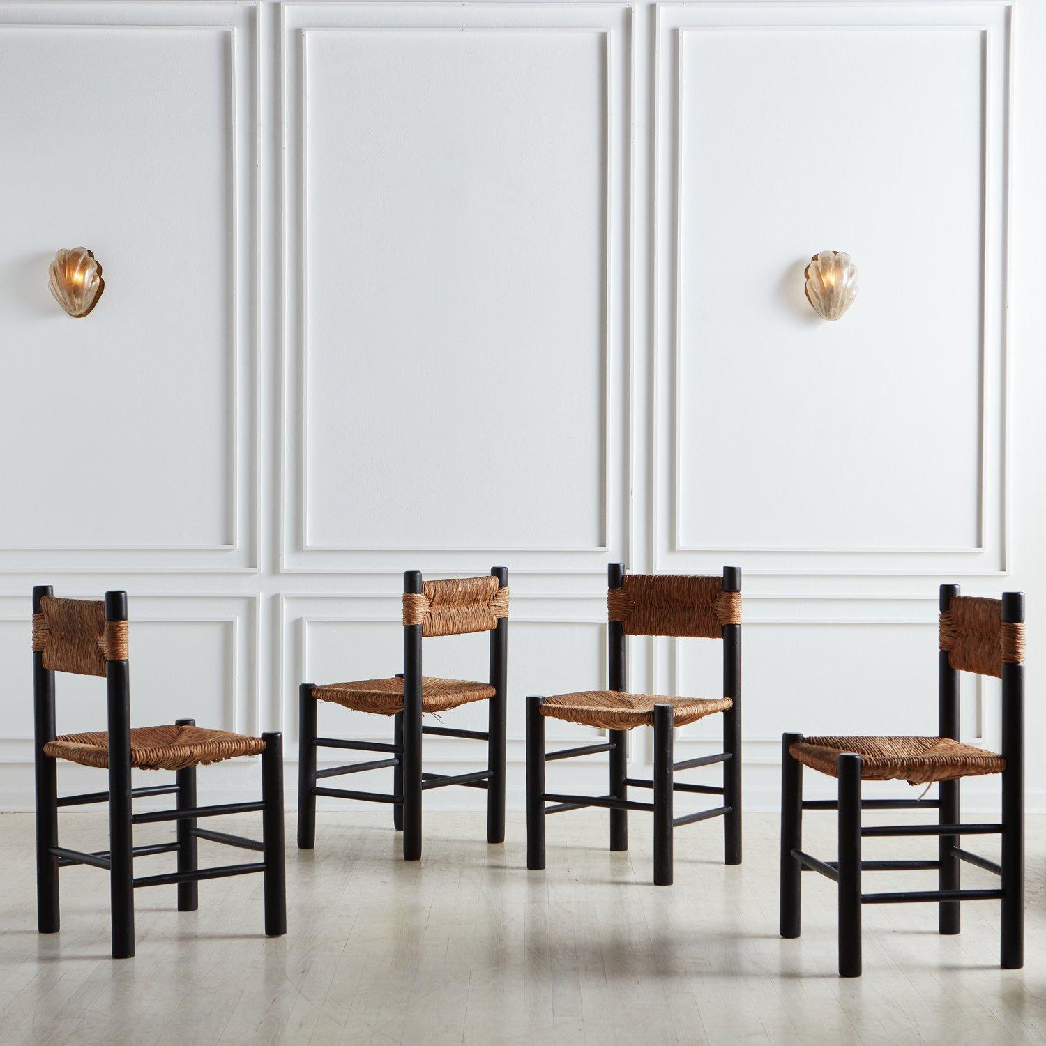 A set of 10 thoughtfully crafted black painted wood & rush dining chairs, reminiscent of Charlotte Perriand and her infamous Dordogne chair for Robert Sentou. Sourced in France, 1950s.

