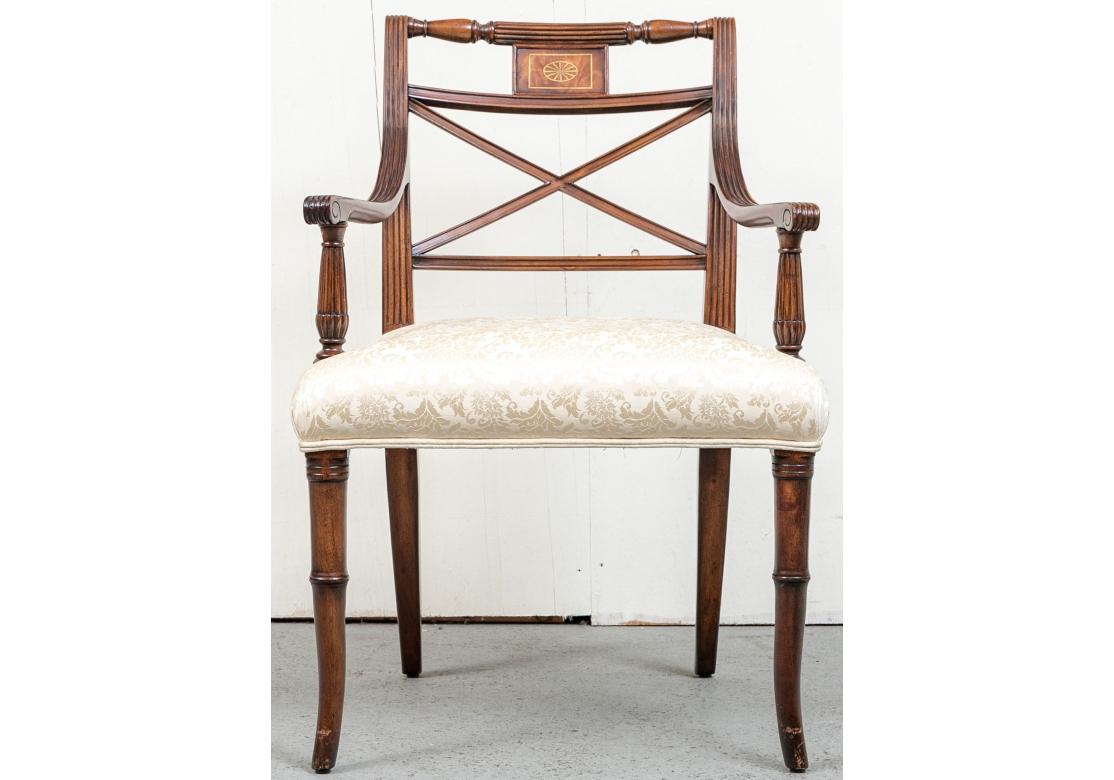 A set of 10 dining chairs comprised of 8 side and 2 arms chairs with tone-on-tone neutral upholstered seats. The chairs with X-form back splat, reeded cresting rail with gold floral medallion, bamboo form front and saber form smooth back legs. Both