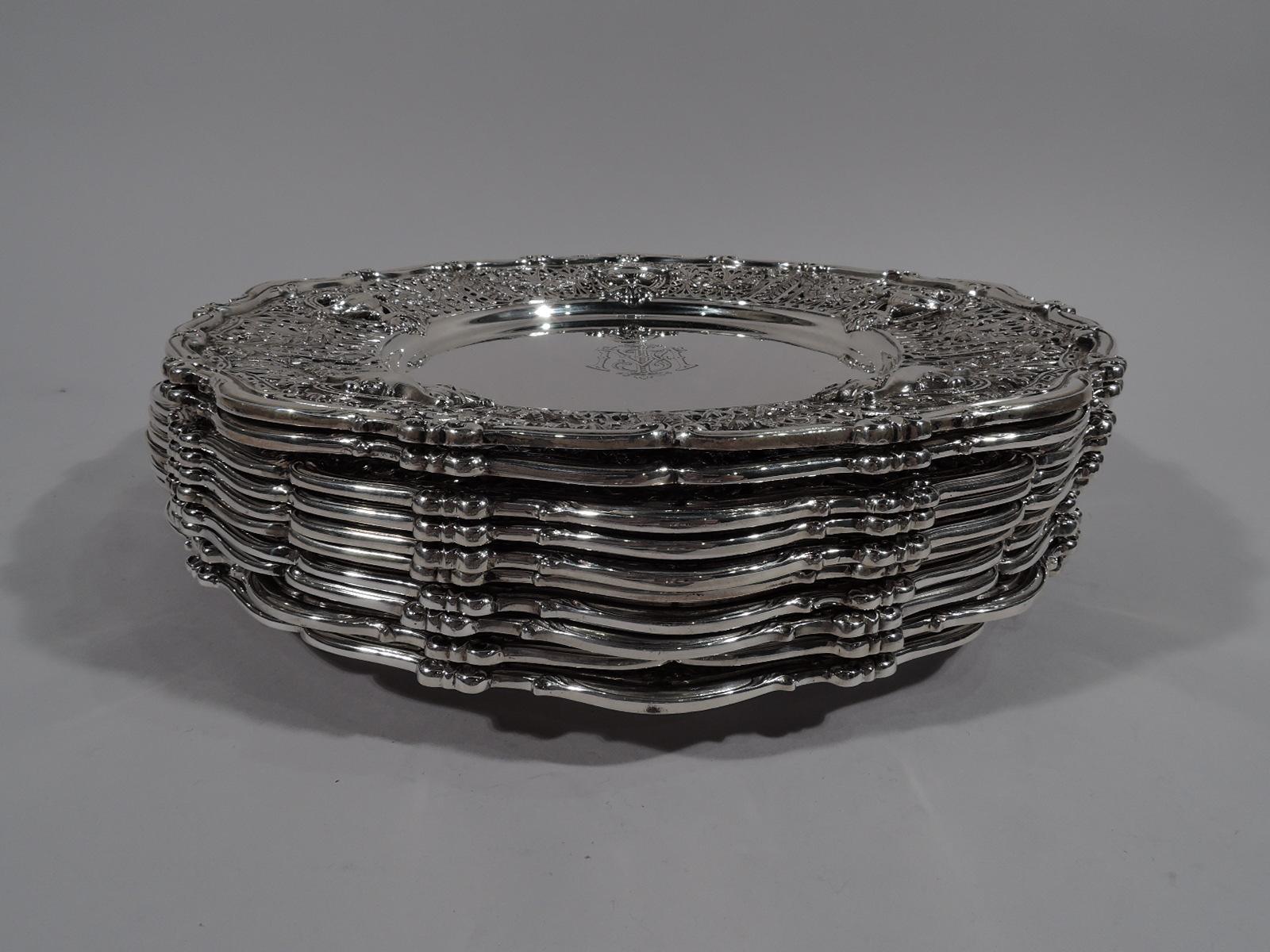 Set of 10 Edwardian Regency sterling silver dinner plates in Adam pattern. Made by Shreve & Co. in San Francisco, circa 1915. Round solid well. Wide shoulder with classical vases on open rondels joined by leaf swag on pierced fern ground. Scrolled