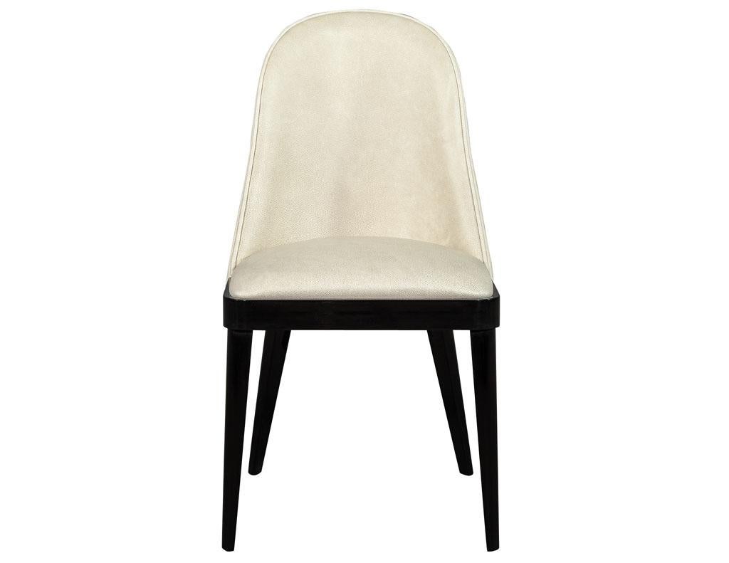 Set of 10 svelte custom modern leather dining chairs by Carrocel. Elegantly sculpted curved backs and hand polished black lacquer legs and trim. These chairs are upholstered in a designer Italian butter soft cream leather. The frames are made in