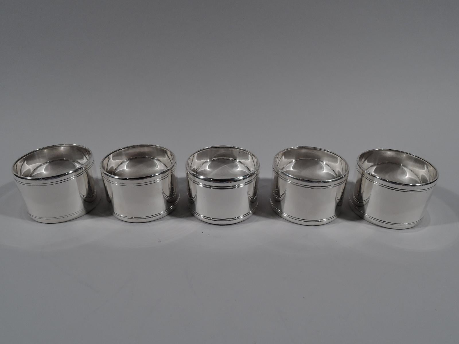 Set of 10 Mid-Century Modern sterling silver napkin rings. Made by Tiffany & Co. in New York. Each: Plain with engraved double bands at top and bottom. Marked “Tiffany & Co. Makers Sterling”. Total weight: 18 troy ounces.
