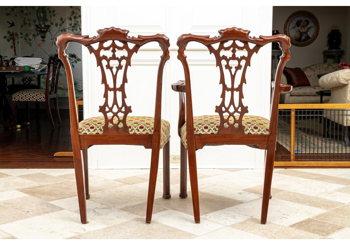 Set di dieci sedie da pranzo in stile Chippendale. Con dettagli classici Chippendale intagliati a foglia e stecche traforate. I sedili sono rivestiti di un velluto floreale rosso e verde.
Il set comprende: 
Dimensioni: Poltrone (2): 24 1/2
