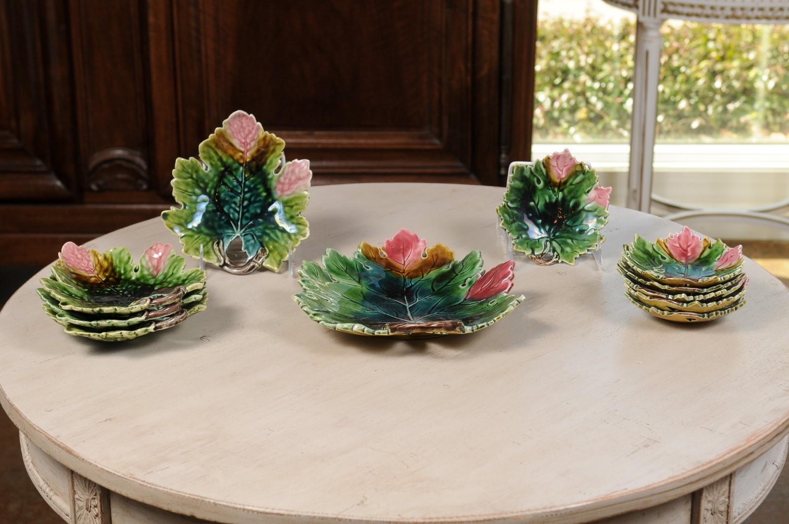 A set of 11 French Majolica leaf dinner plates from the 19th century, with pink, green and brown décor. Born in France during the 19th century, each of this set of majolica plates charms our eyes with its whimsical silhouette. Shaped as leaves, the