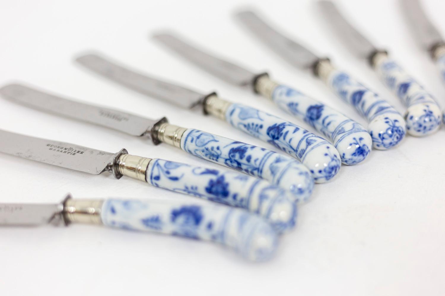 Set of 11 knives with curved blue and white enameled handles decorated with a vegetal decor. Curved silver blade. Signed Georg Müller Garantie on the blade.

Work realized in the 19th century.

Uses on the steel blade.