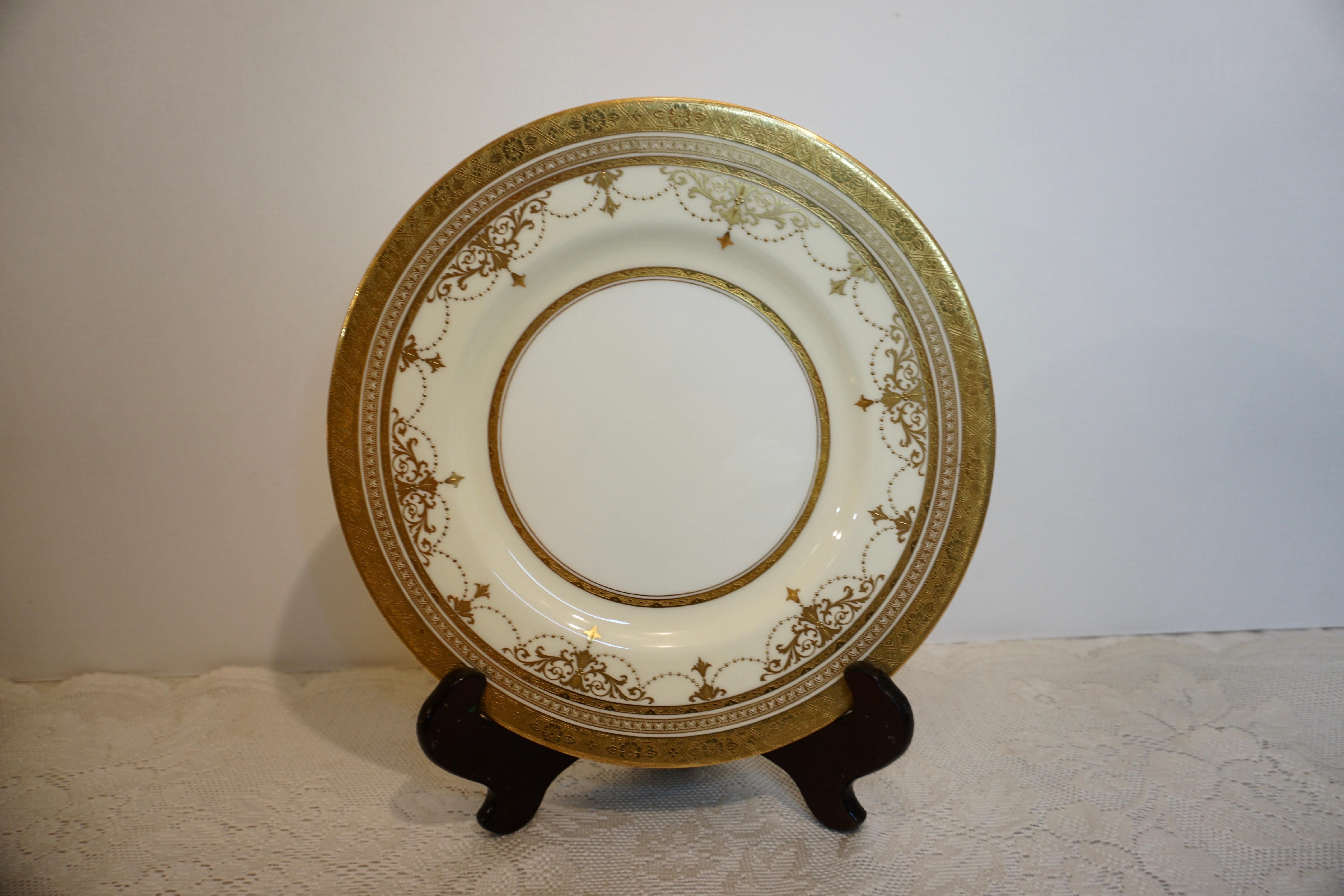 Set of eleven fabulous Minton dinner plates decorated with garlands of raised gold arabesque and raised gold jeweling. They have a gold border with an embossed decoration. They are large, 10.5 inches in diameter. They were made exclusively for
