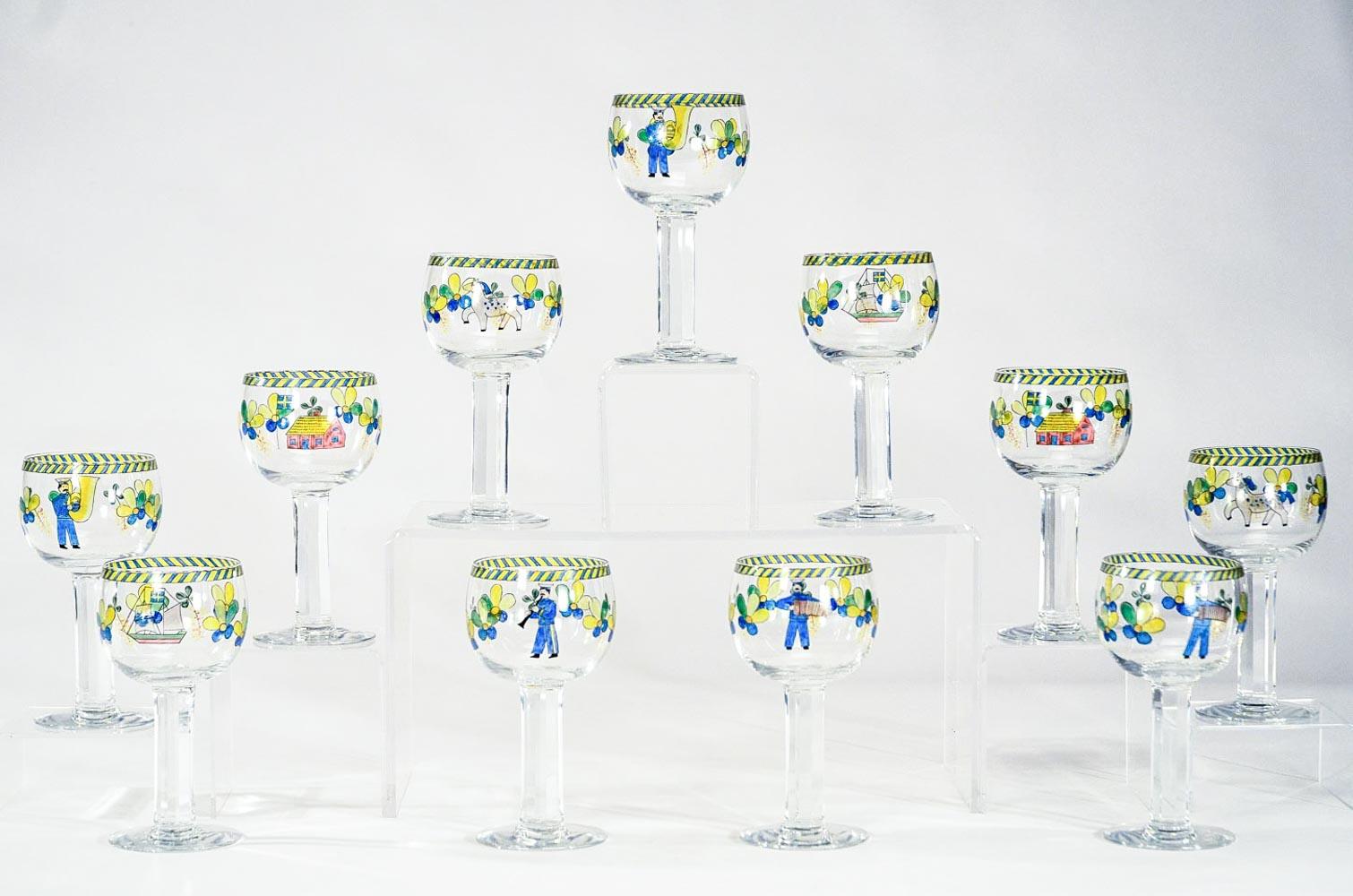 A wonderful set of 11 large goblets, made by Orrefors with panel cut and polished columnar stems. Each signed glass is individually hand painted with whimsical and playful 