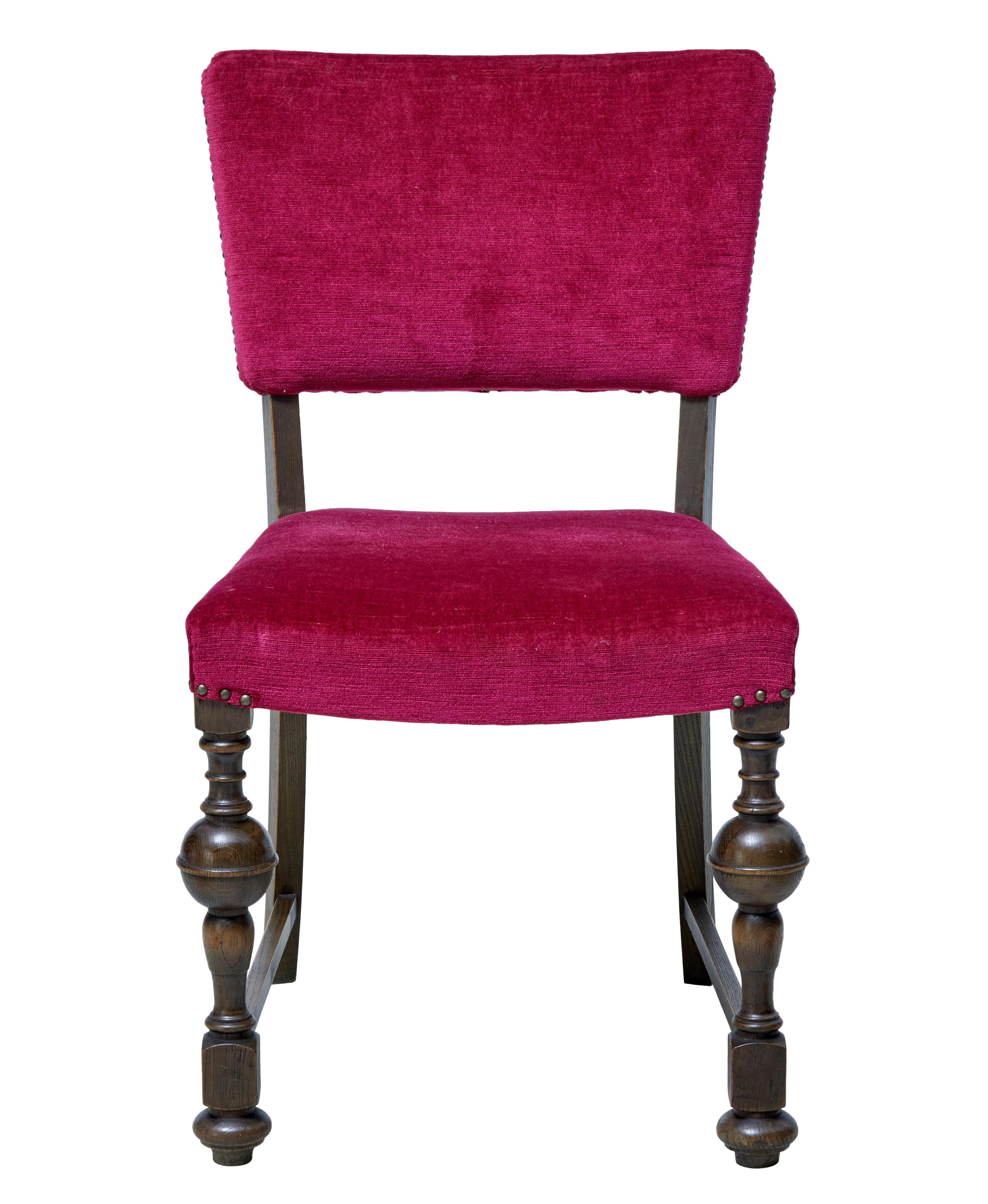 Striking set of 12 near pink upholstered dining chairs, circa 1920.

Later covered in a cerise pink faux velvet covering. Shaped backs and over stuffed seats. Turned front legs united by stretcher to the back tapering leg.

Expected wear and