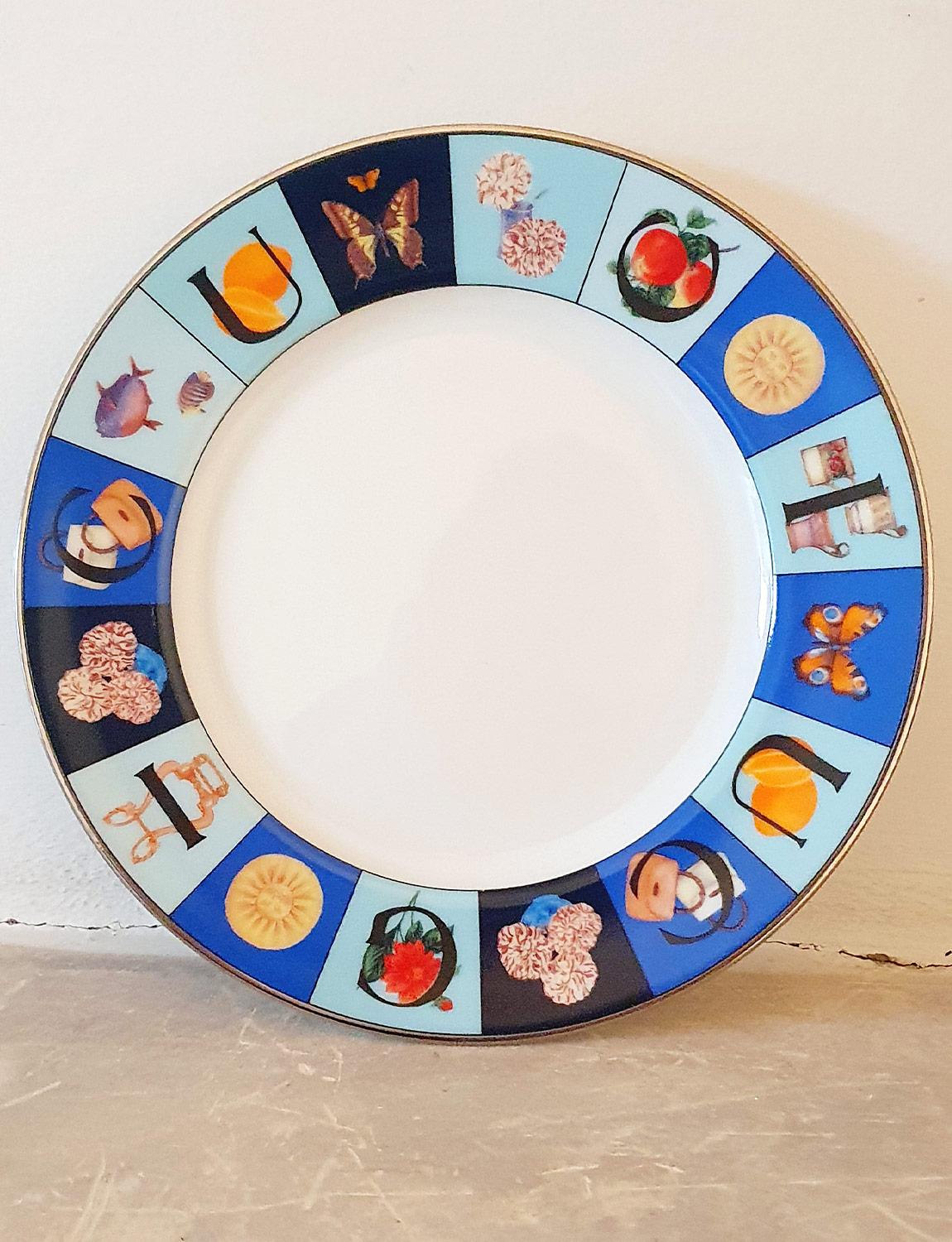 A set of 12 Gucci plates each with a diameter of 22cm in perfect condition in their original Gucci box. The plates were part of the 1980s Guccissimo range and are decorated in shades of blue around the rim, the letters spelling G U C C I and with