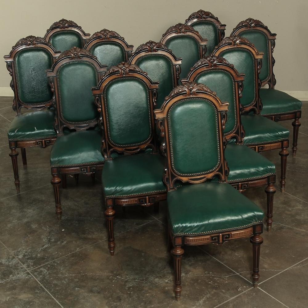 Set of 12 19th century French walnut dining chairs from the Napoleon III period with ebonized molded detail and lavish hand carved embellishment atop the seatback crowns will make an elegant addition to your dining experience! Ancient Greek