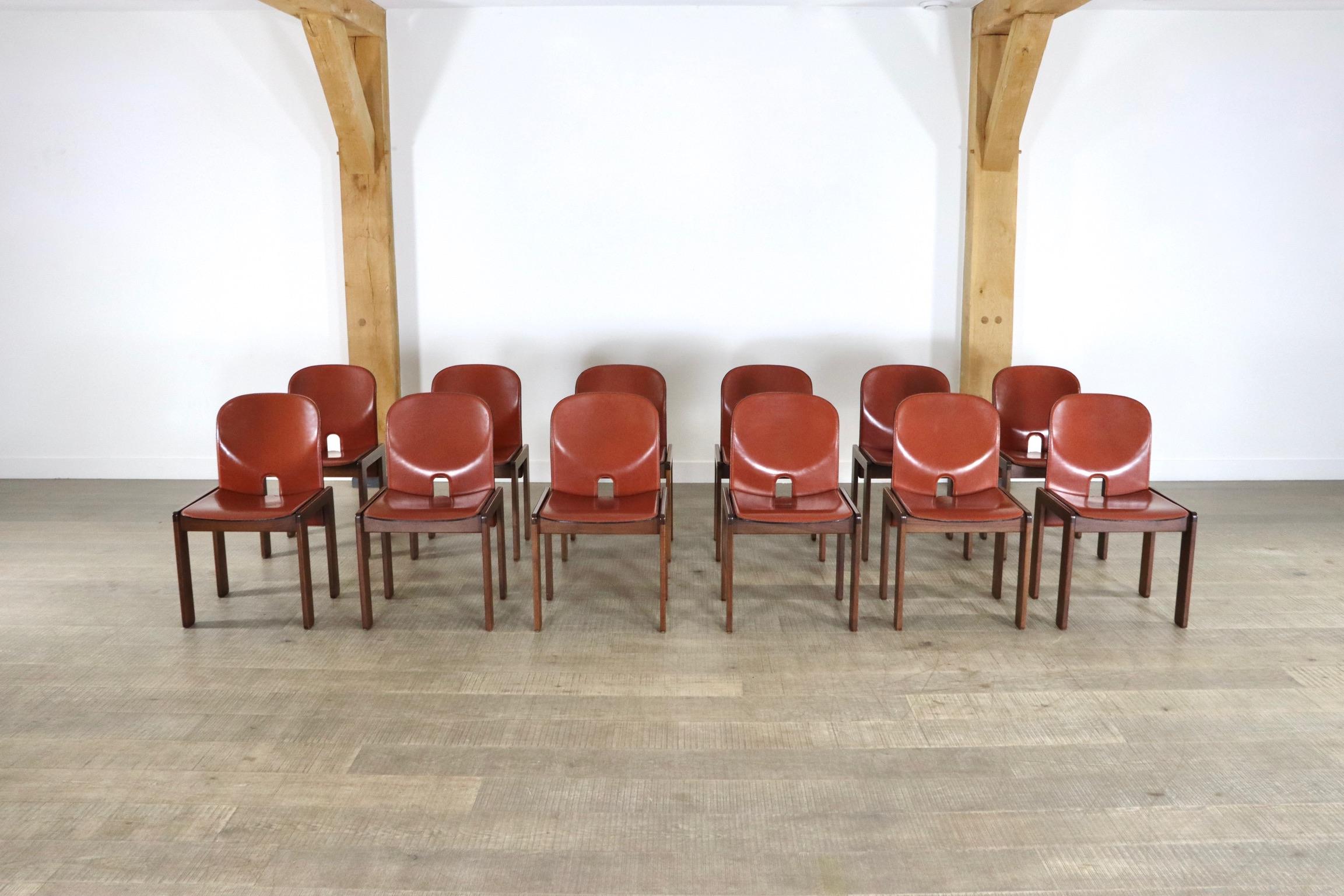 Outstanding set of 12 model 121 dining chairs in cognac leather by Afra and Tobia Scarpa for Cassina, 1965. The chairs have walnut wooden frames and plywood seats and backs covered with the original cognac leather. All chairs are marked with a