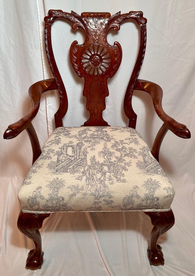 Set of 12 antique 19th century English carved walnut wheel-back dining chairs.
New upholstery
2 Armchairs with Toile Fabric: 
-H: 39 inches
-W: 21 inches
-D: 17 1/2 inches
10 Sidechairs with striped fabric: 
-H: 39 inches
-W: 22 inches
-D: