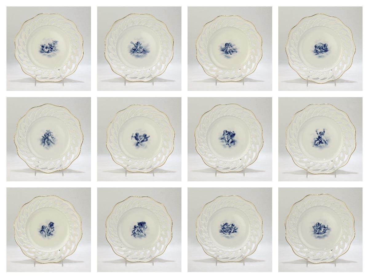 An extraordinarily fine set of Meissen Porcelain cabinet plates.

Each with a gilt scalloped rim, a pierced or reticulated border (with a left-hand twist), and centers with varying hand painted, blue underglaze scenes of cherubs or putti.

The