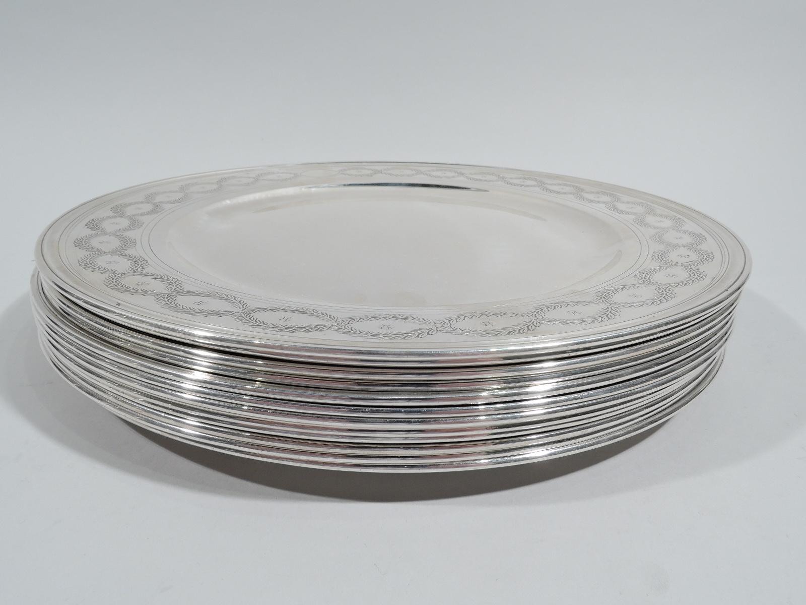 Set of 12 Winthrop sterling silver dinner plates Made by Tiffany & Co. in New York, ca 1920. Each: Round well and wide shoulder with acid-etched laurel-wreath border inset with flower heads. Fine pieces in the historic pattern that was first