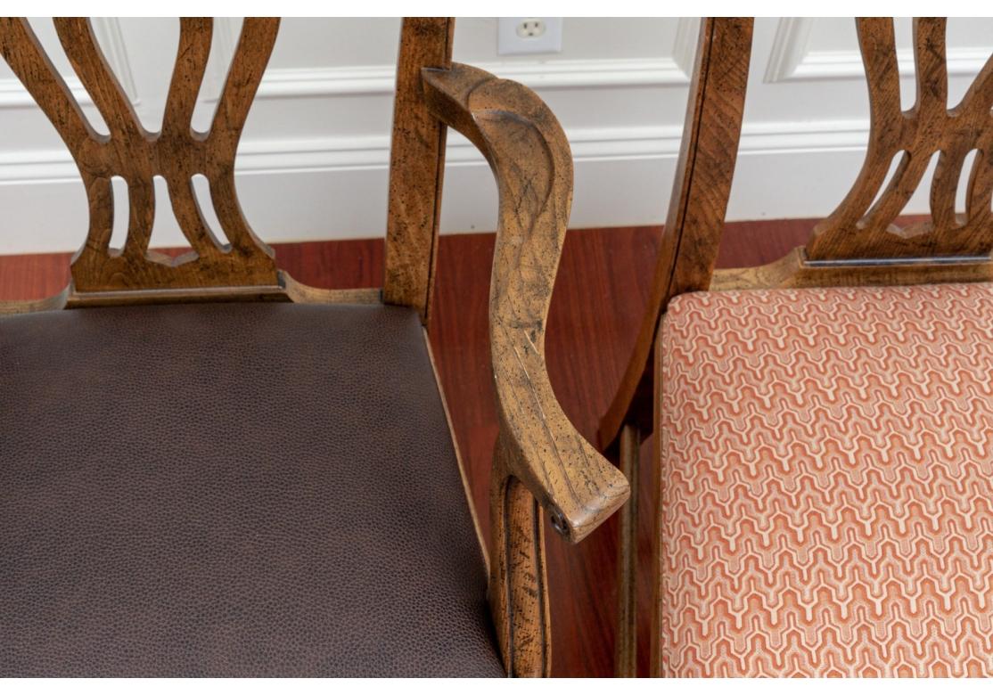 Ensemble de 12 chaises de salle à manger de Baker Furniture comprenant 4 chaises à accoudoir avec des sièges en similicuir et 8 chaises latérales avec des sièges rembourrés. Les chaises sont dotées d'un dossier ajouré, d'une traverse à volutes, d'un