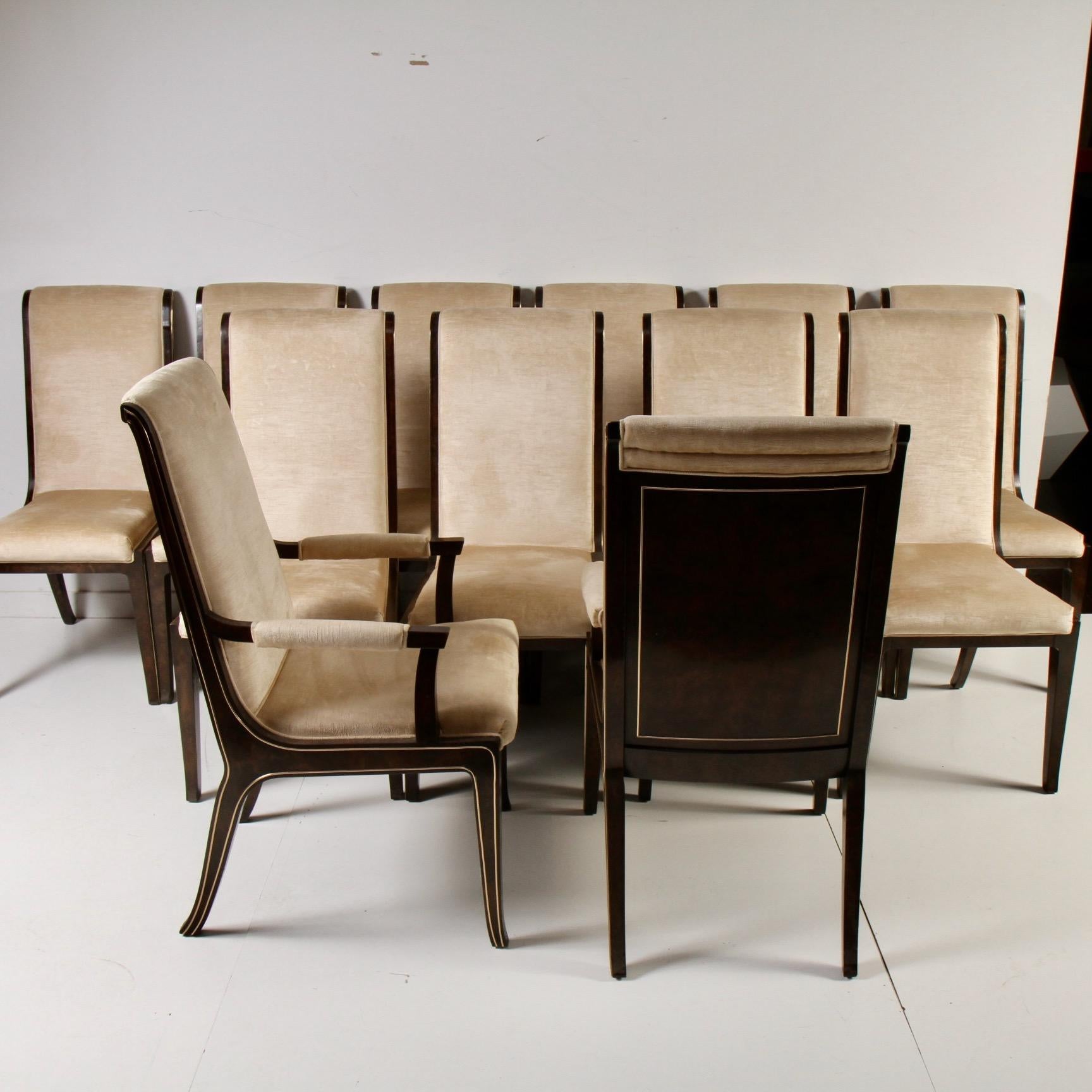 Clean, original set of ten side and two armchairs designed by Bernhard Rohne for luxury furniture maker Mastercraft. Chairs are upholstered in champagne velvet with brass inlay trim. Dining table for this set is in another of my