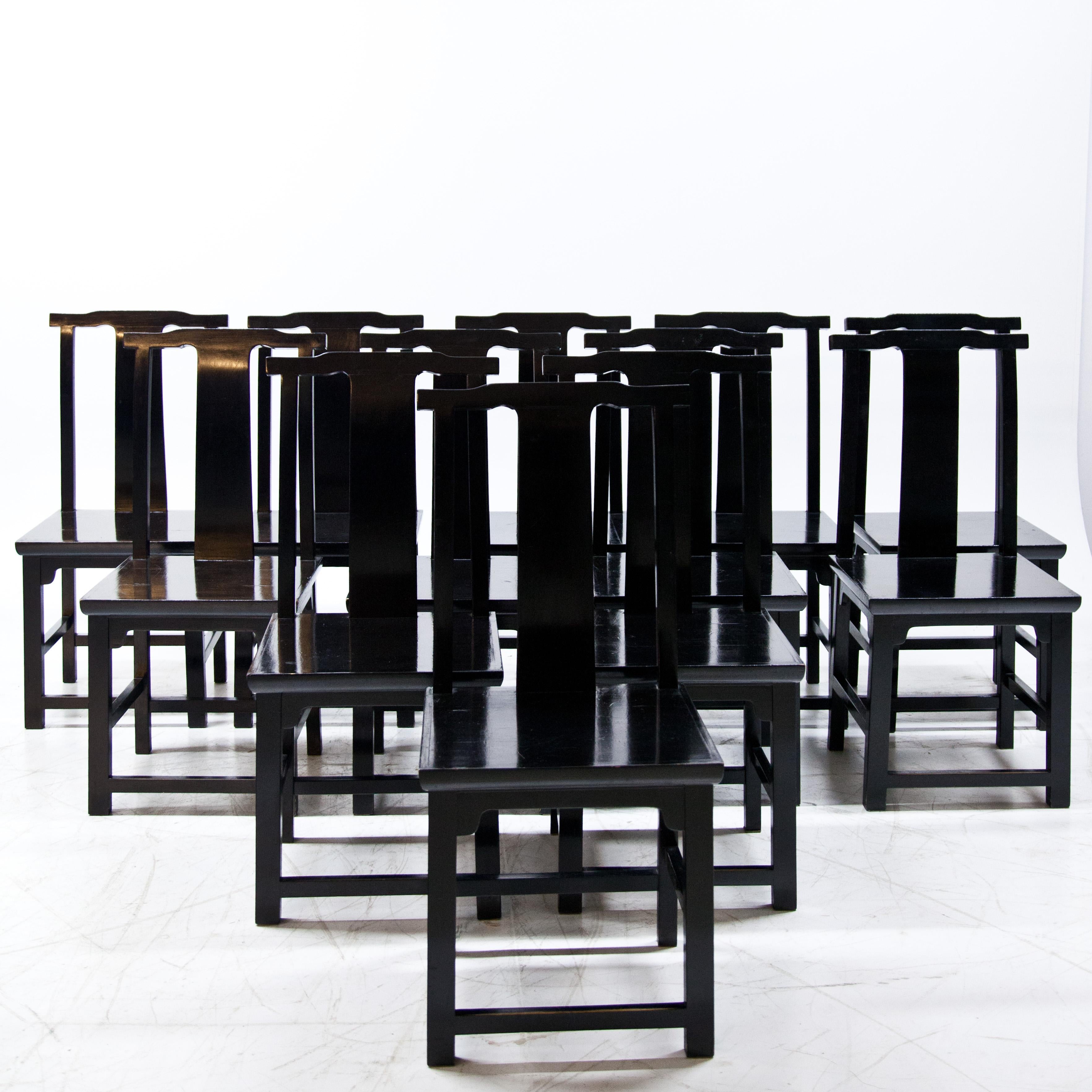 Satz von 12 schwarz lackierten Holzstühlen im japanischen Stil mit hohen Rückenlehnen und geraden Sitzen.