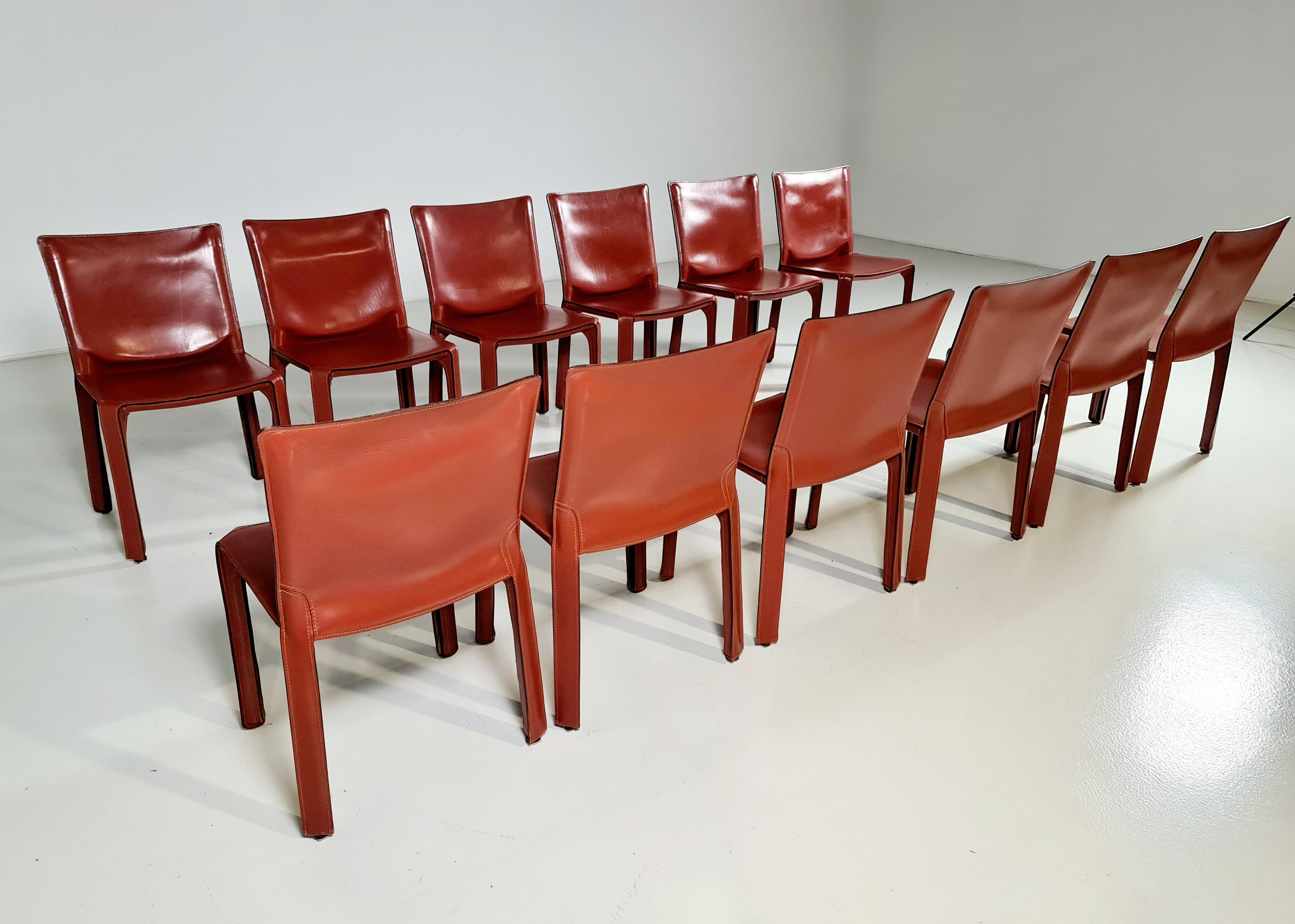 Set of 12 CAB-412 dining room chairs in Russian Red (also known as Bulgarian Red) saddle leather. Designed by Mario Bellini and manufactured by Cassina in the 1970s in Italy. The leather cover is stretched over a minimal tubular steel frame. The