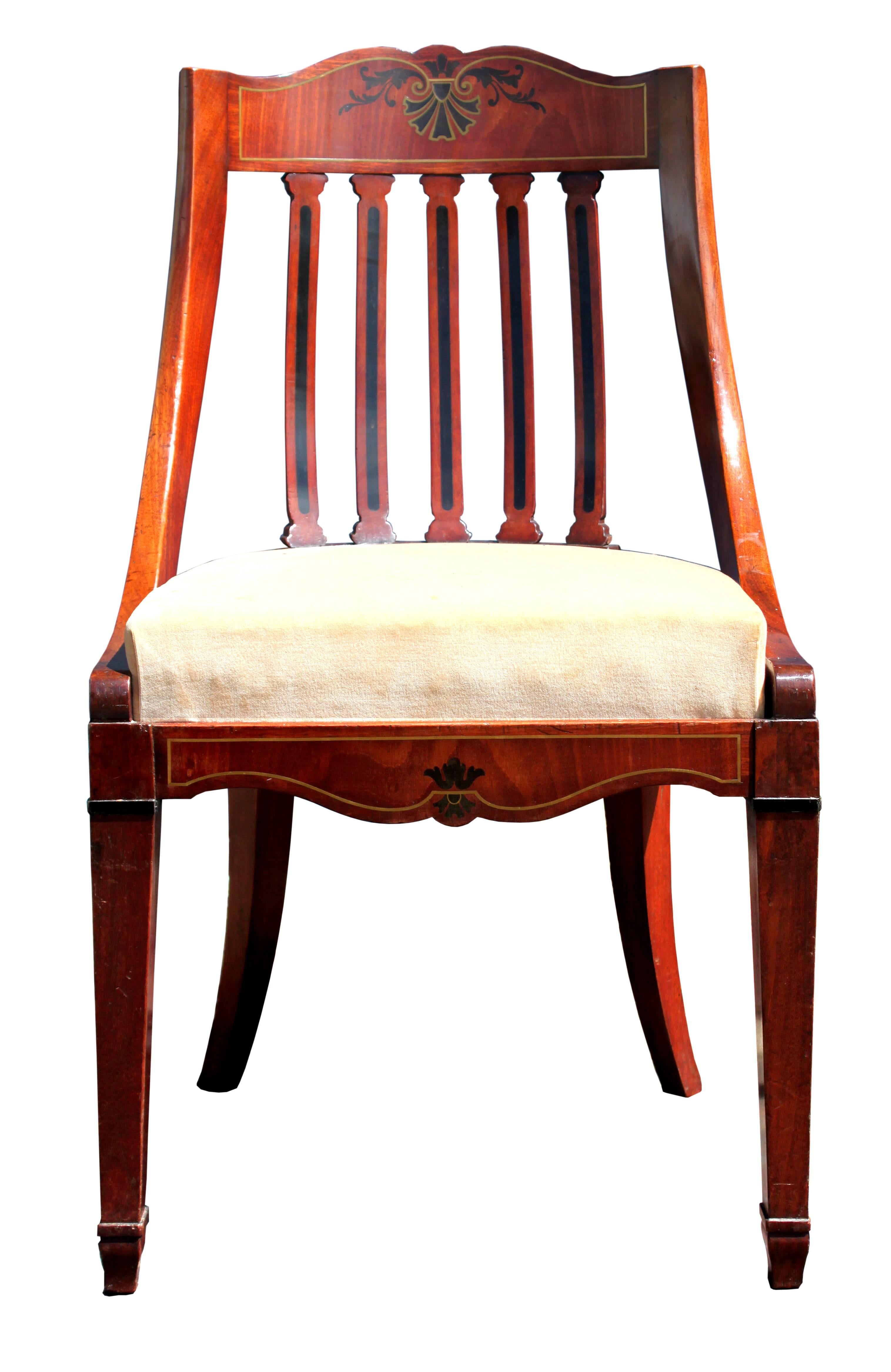 A good set of 12 mid-19th century dining chairs, probably Northern European, maybe Danish; in mahogany with the fronts handsomely inlaid with acanthus decoration in ebony and brass; elegant tub-shaped form and very comfortable to sit on; in