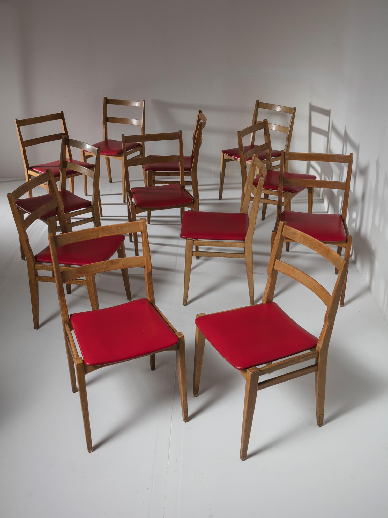 Set of twelve dining chairs by Melchiorre Bega for Cassina.
Comfortable and compact chairs with artificial leather seats.