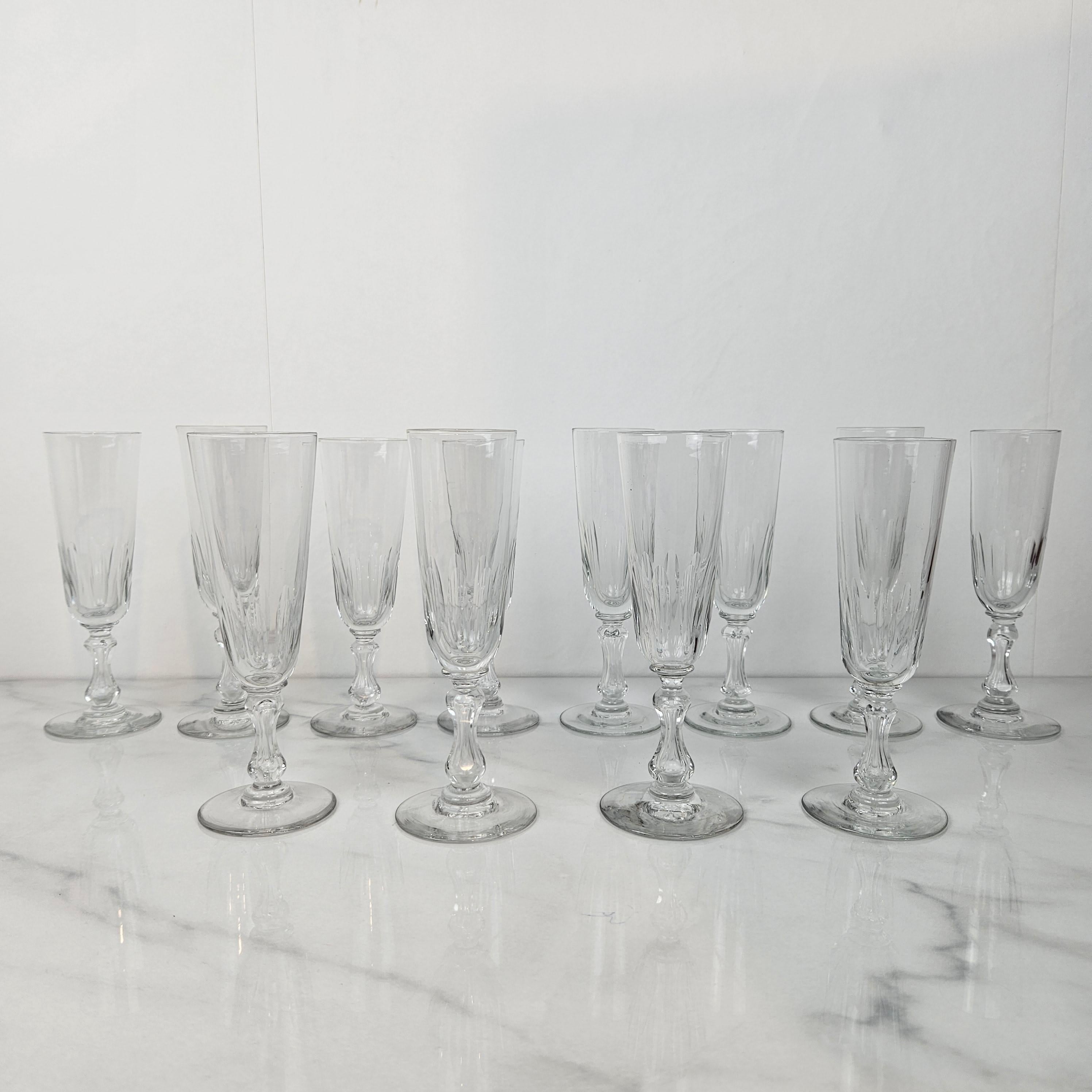 Un ensemble raffiné de douze coupes à champagne françaises anciennes, fabriquées en verre clair vers 1890. 
Les flûtes sont dotées d'un bol inférieur magnifiquement taillé et d'une tige avec des détails décoratifs taillés, offrant à la fois un