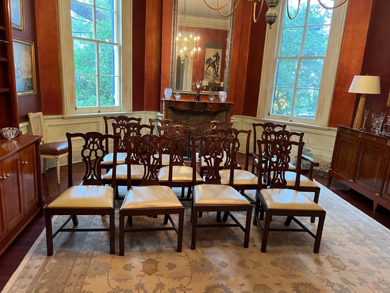 Lovely set of 12 Maitland Smith Chippendale-style chairs with carving. There are two armchairs and 10 side chairs. The seats are upholstered with pale gold vegan leather. The chairs are mahogany, with carving in the wood, and in very good condition.