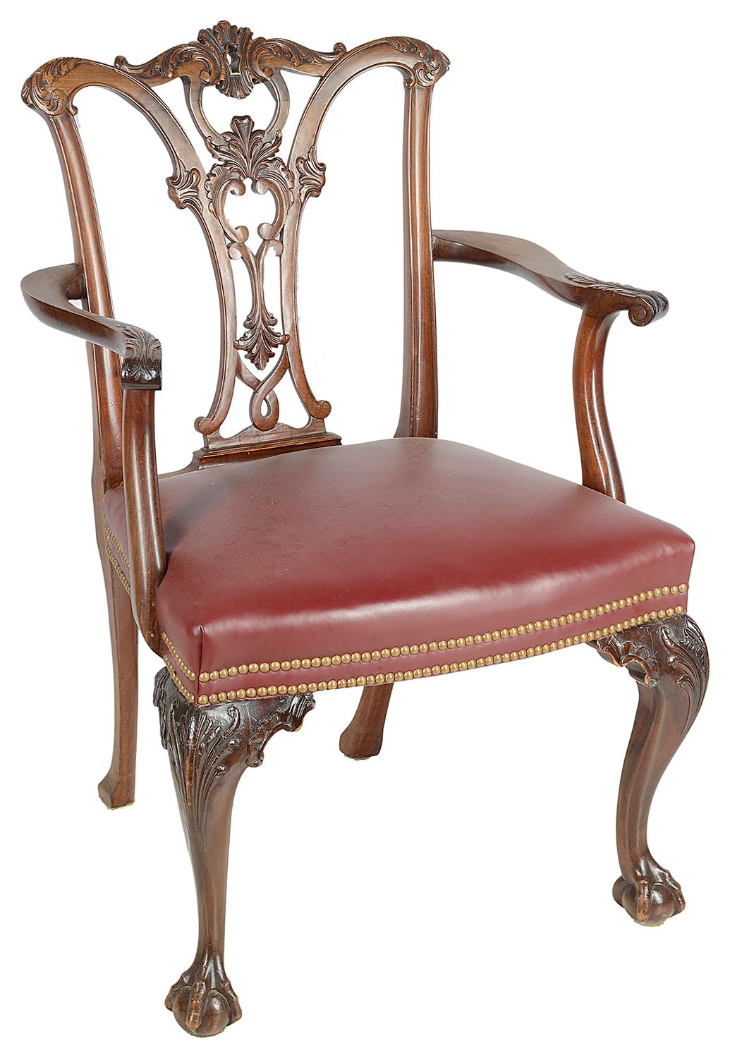 A good quality set of twelve (10 + 2 arms) late 19th century mahogany Chippendale style mahogany dining chairs, each having wonderful carved and fretted back splats of scrolls and foliage. Burgundy colour hide upholstered seats with two lines of