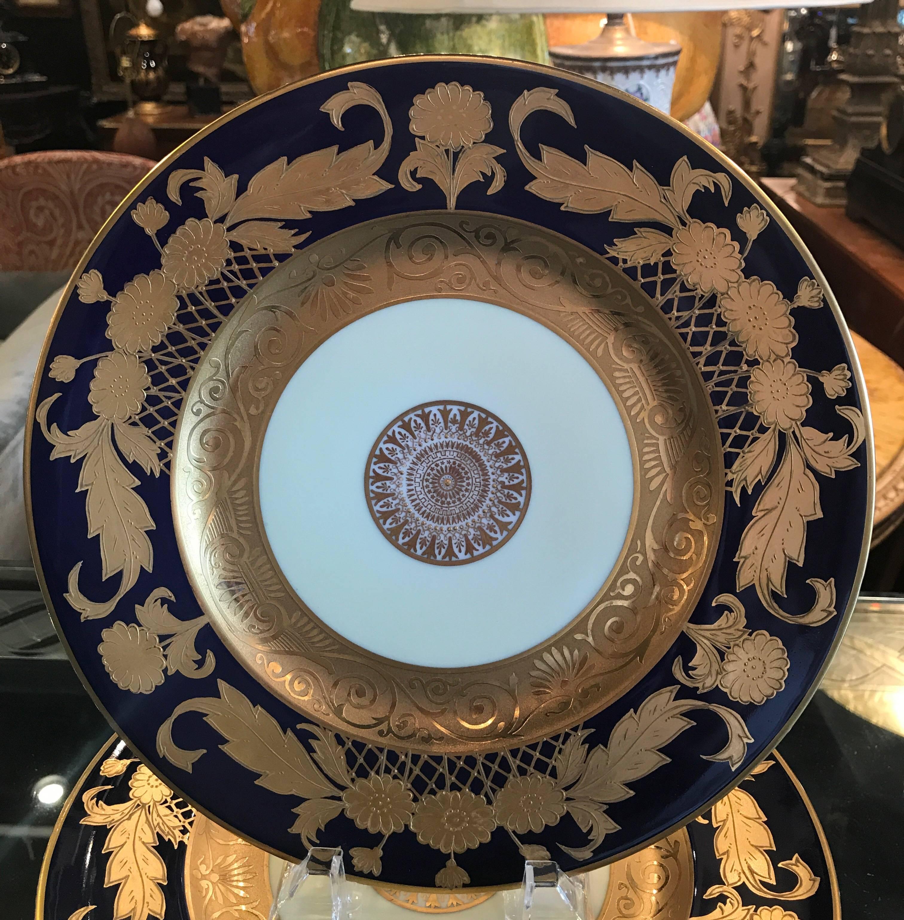 A set of 12 cobalt and gold encrusted service plates by Hutschenreuther. Opulent borders of raise gold with a rich cobalt blue background with centre medallion.