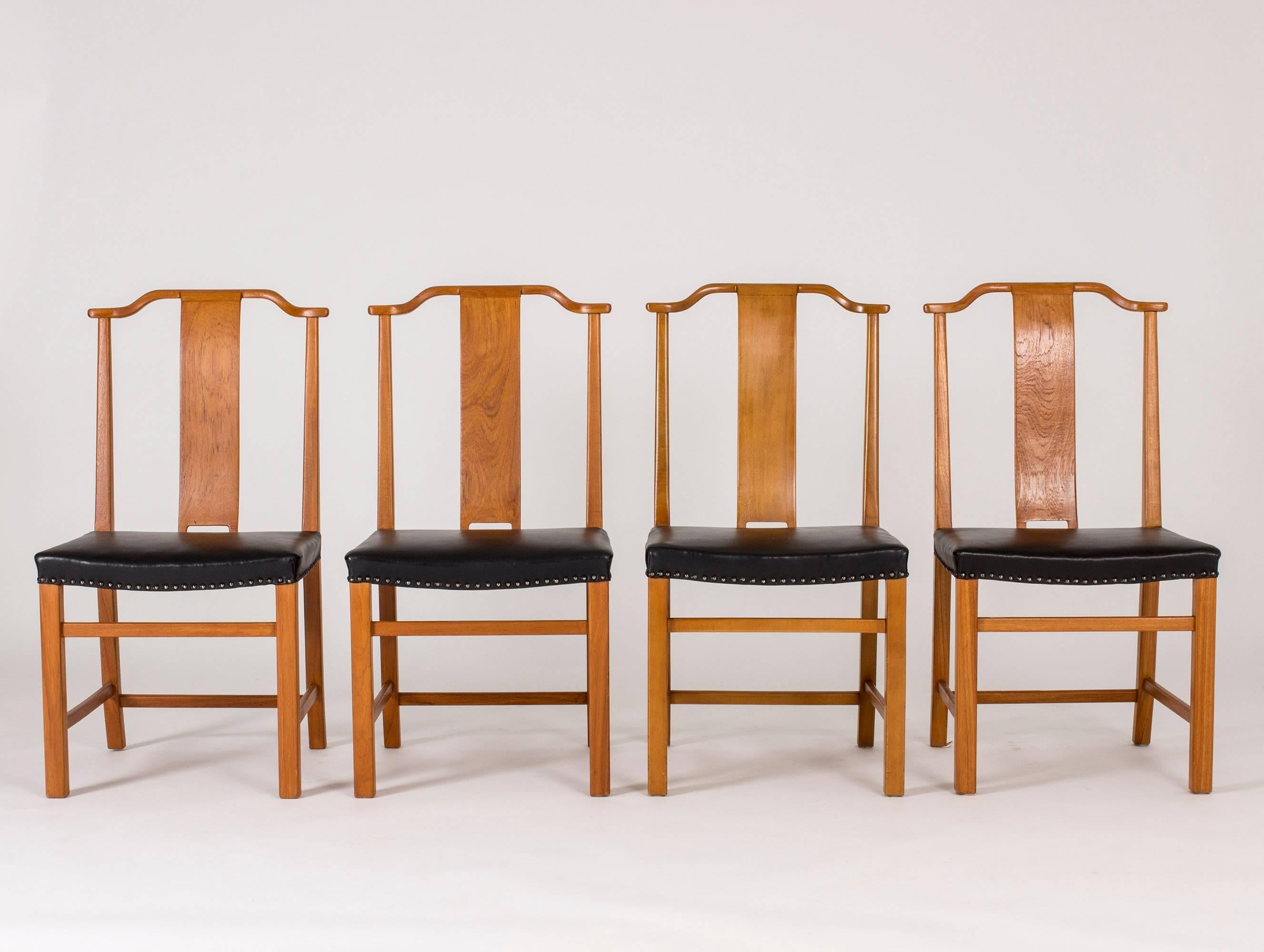 Set of 12 beautiful dining chairs in stained elmwood and leather by Axel Larsson, custom-made for a Swedish Court of Appeals. Dignified design with tall backs, discreet curves and a stable base.
