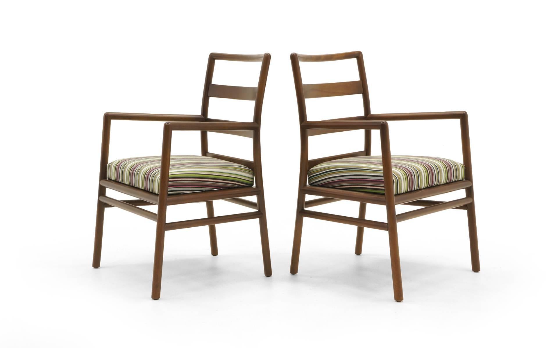 Set of twelve dining chairs designed by T.H. Robsjohn-Gibbings for Widdicomb. Two arm chairs and ten side chairs. All expertly refinished and reupholstered in Paul Smith Stripe Fabric for Maharam. These are super sturdy, relatively wide dining