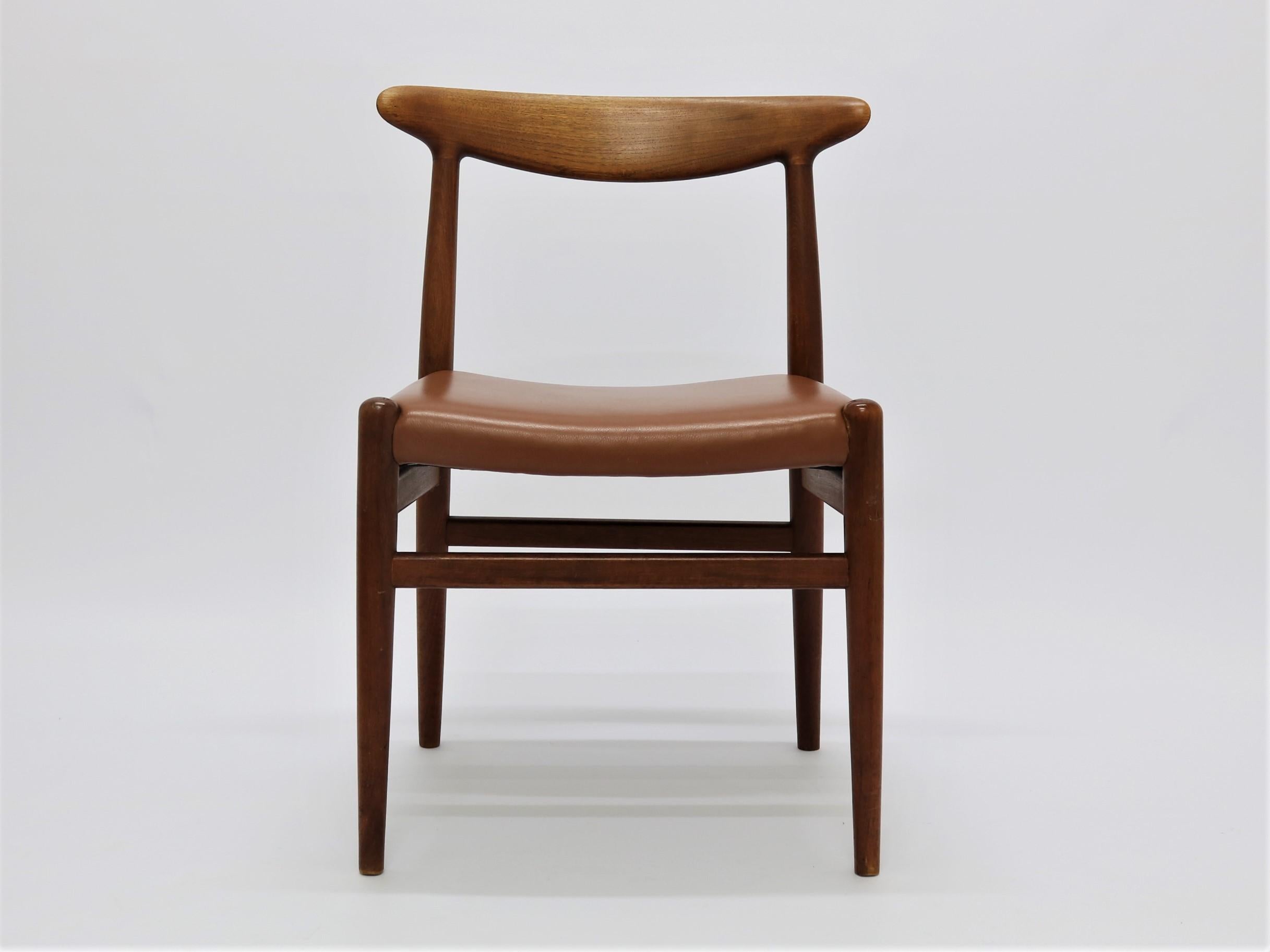Dining chairs in solid teak wood and cognac leather by Hans J. Wegner. Produced and stamped from C.M. Madsens in Odense, Denmark in the 1950s. All 12 chairs have only had one owner and has always been a set.