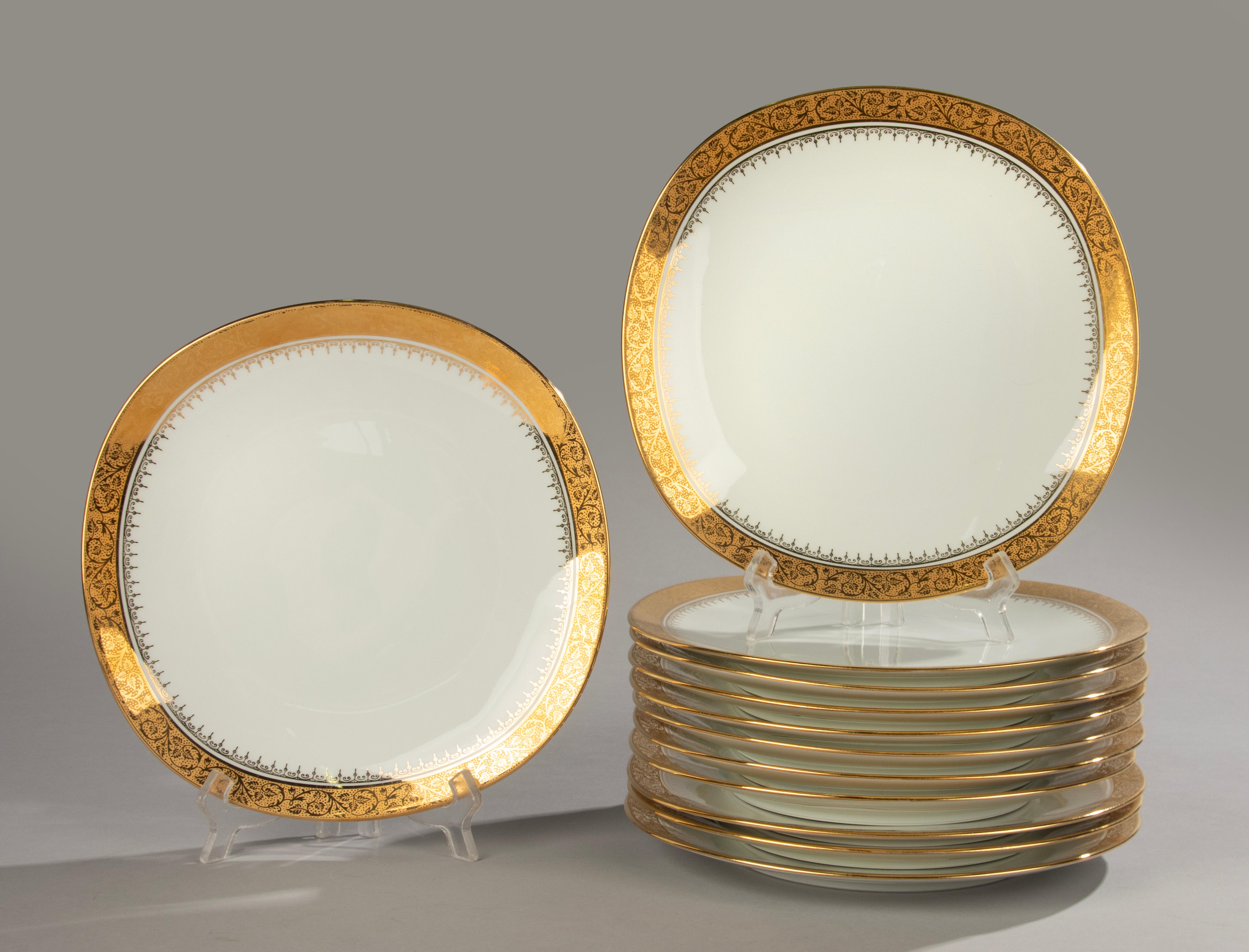 A beautiful set of 12 porcelain dinner plates, made by the French brand Raynaud Limoges. 
Hand-painted (Décor Main) with rich gold decoration (Deux Feux or), fired twice and produced in limited edition (Tirage limité).
These square plates measure 23