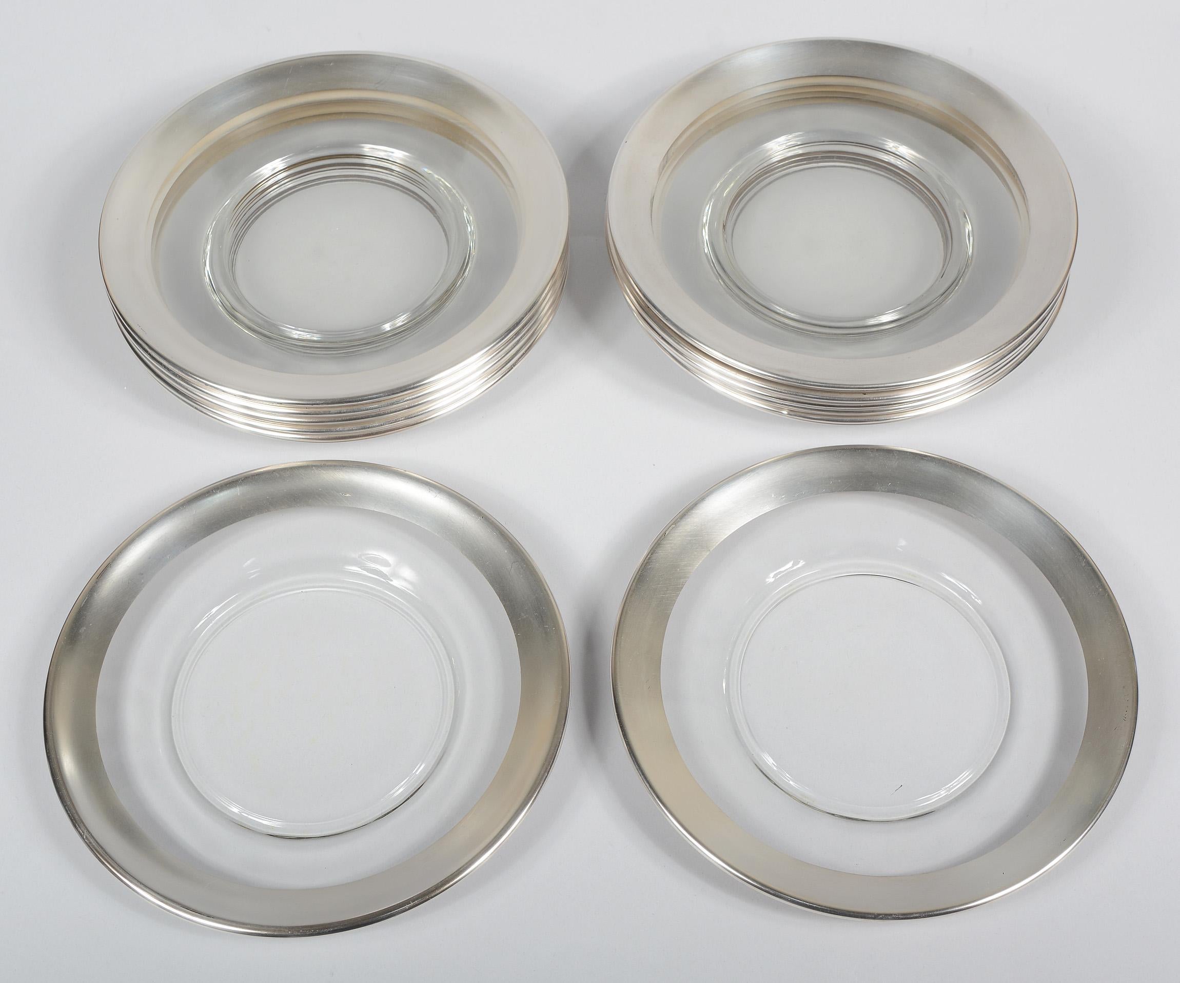 Twelve silver rim luncheon size plates by Dorothy Thorpe. These plates are in overall good condition. There are some signs of use and a few spots of losses and scratches to the silver. One plate has a small nick on the edge of the rim.
