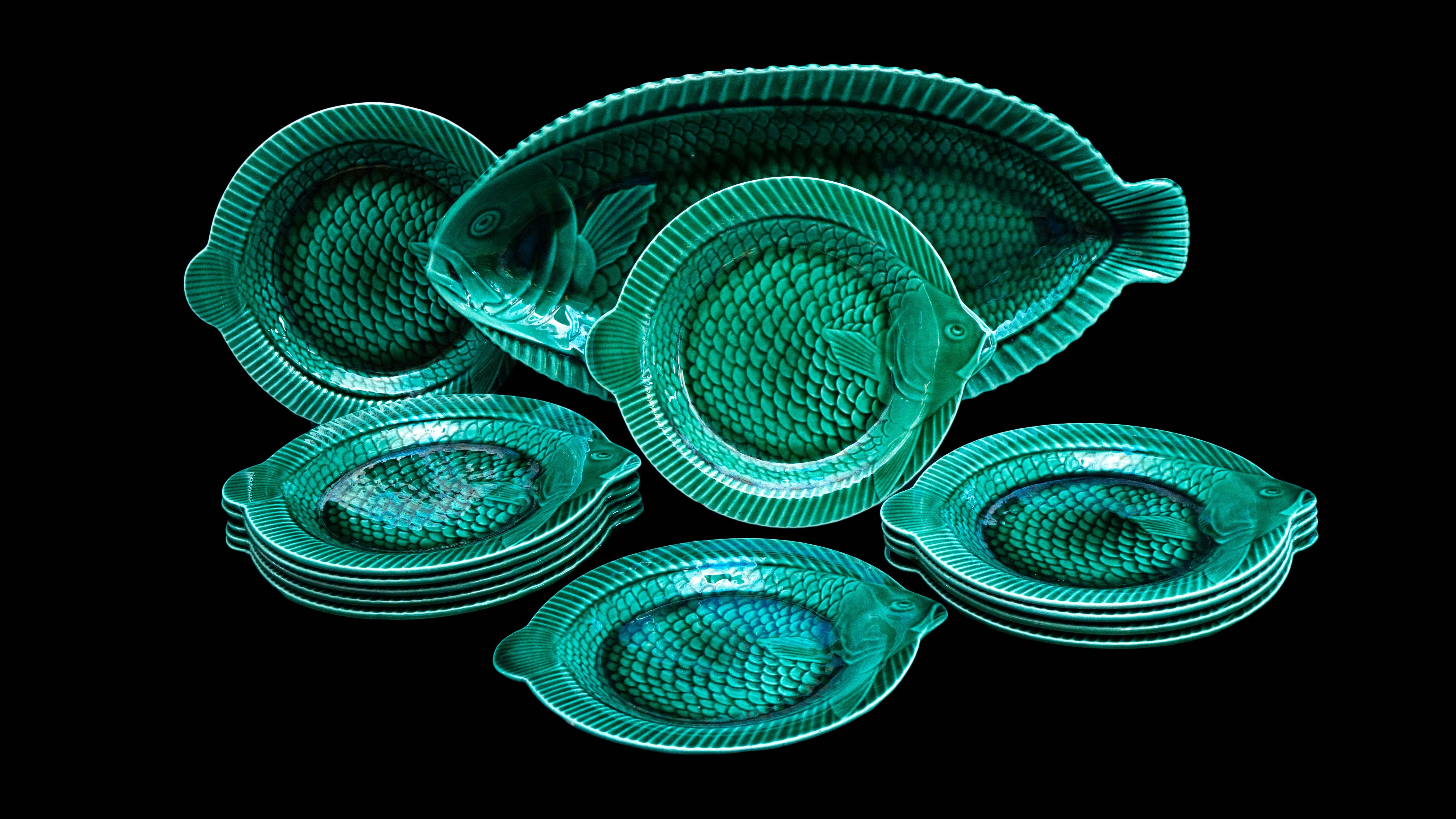 Set of 12 Emerald green fish plates with large serving platter by Sarreguemies. Sarreguemines, french faïence, green majolica glazed fish service of 12 plates and one large serving platter. the round plates have raised rims with protruding fish