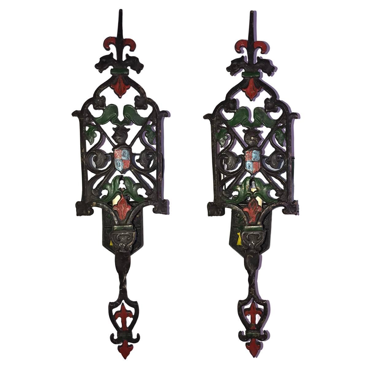 A set of twelve circa 1920's English cast iron single light sconces with hammered finish and painted details. Sold in pairs

Measurements:
Height: 23