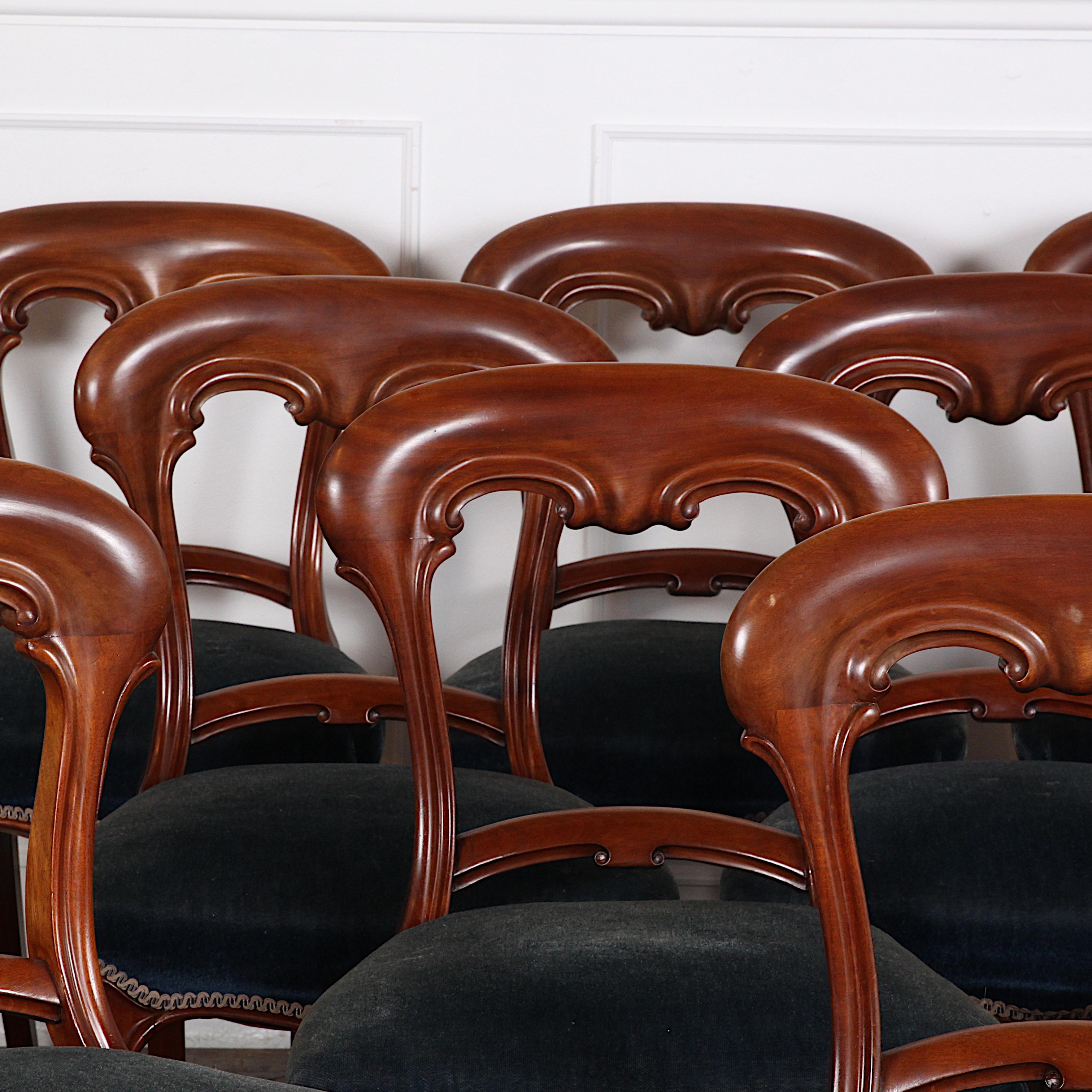 Hard-to-find set of 12 English Victorian period dining chairs in Mahogany with shaped carved backs and elegant cabriole front legs.