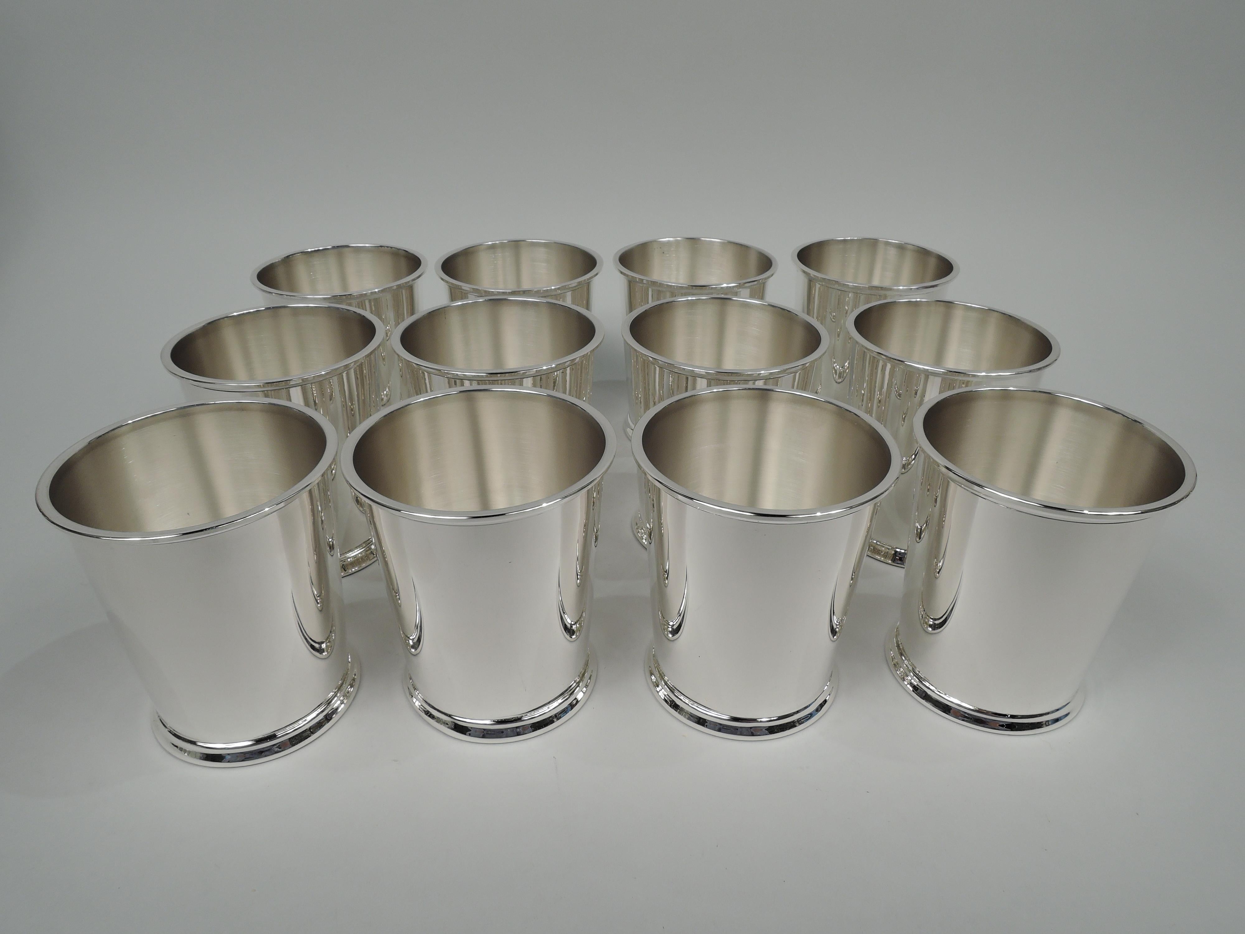 Set of 12 sterling silver mint julep cups. Made by Fisher Silversmiths, Inc. in Jersey City. Each: Straight and tapering sides, flat molded rim, and skirted foot. Fully marked including maker’s stamp and no. 87. Total weight: 47.3 troy ounces.