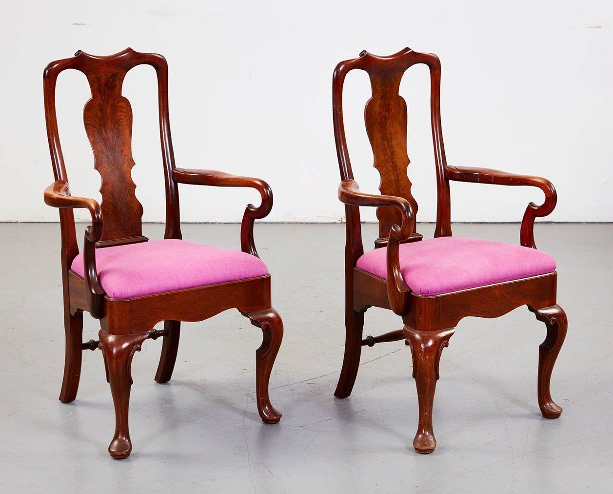 Un ensemble de chaises de salle à manger en noyer comprenant deux fauteuils et dix chaises latérales de style Queen Anne avec des dossiers en acajou flammé sur des sièges rembourrés avec des tabliers façonnés, tous reposant sur des pieds cabriole à