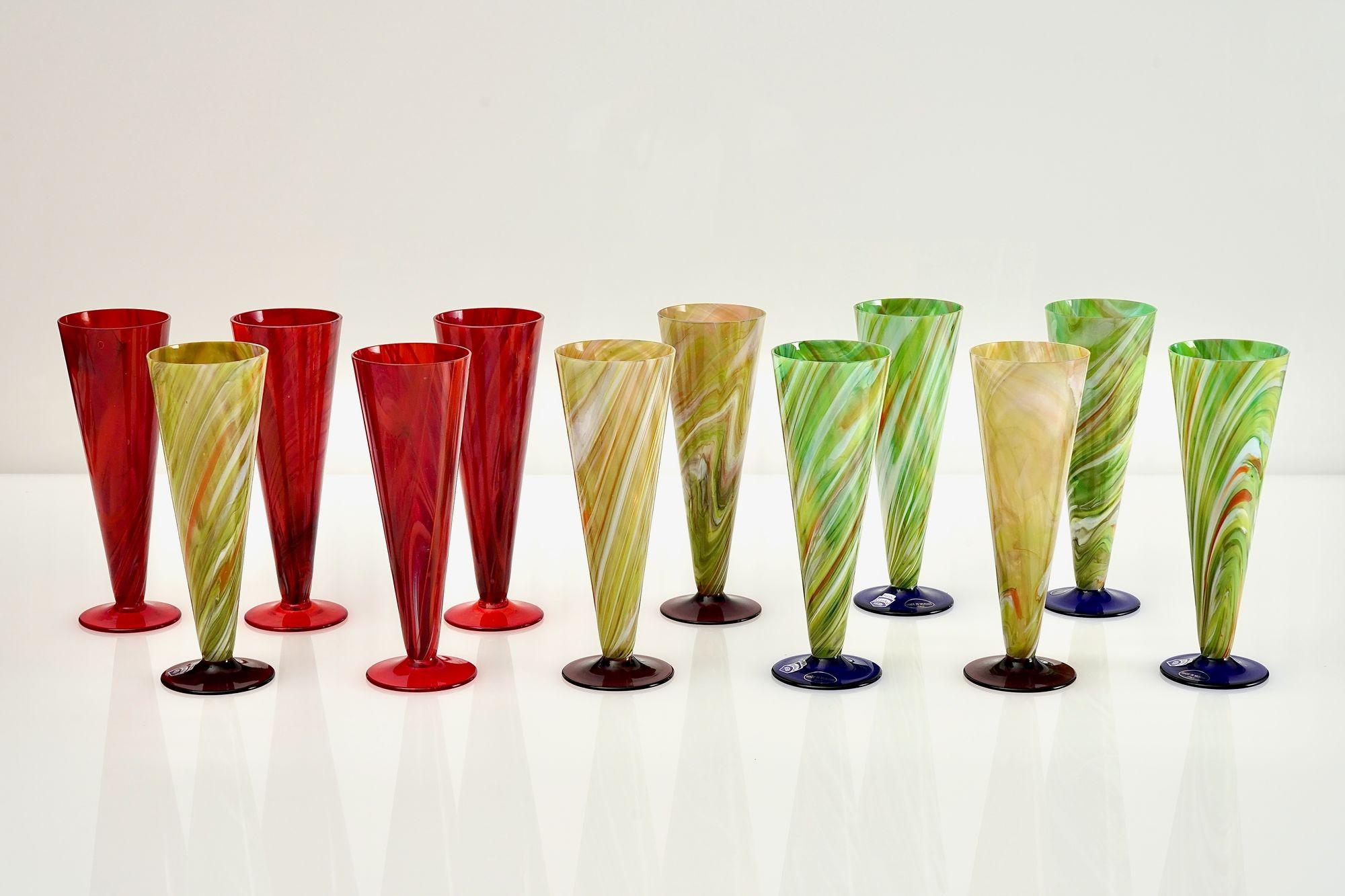 Magnifique ensemble de 12 verres à flûte de Cenedese en verre marbré et pied de couleur unie.

Il existe trois couleurs de base, le rouge, le vert et l'ambre, et chacune porte une couleur de pied différente.

La marbellisation est réalisée avec des