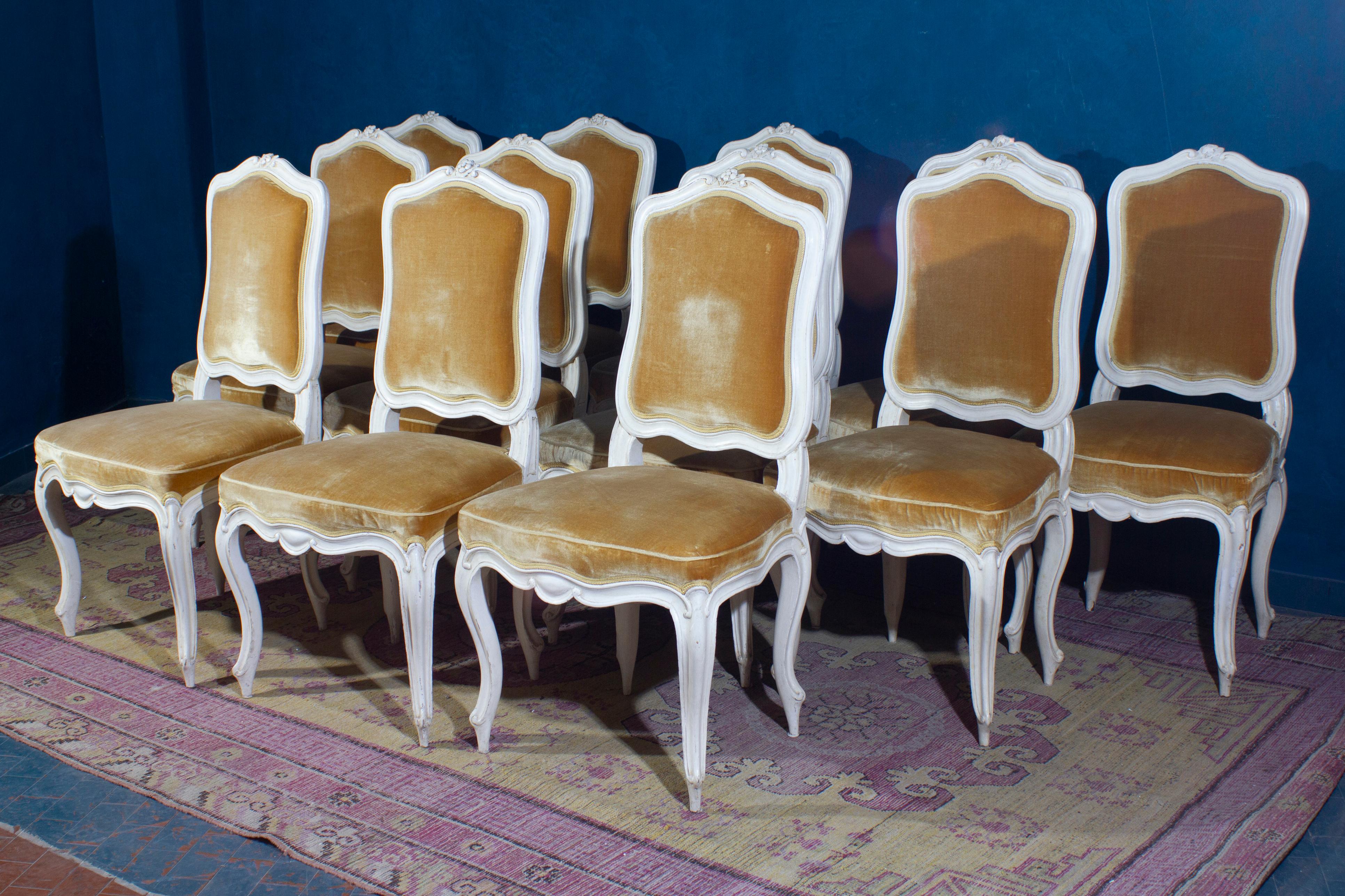 A fine set of 12 French ivory painted chairs with gold color precious silk velvet upholstery in very good condition. 
6 chairs are original 18' century and 6 are made in the 20' century.

