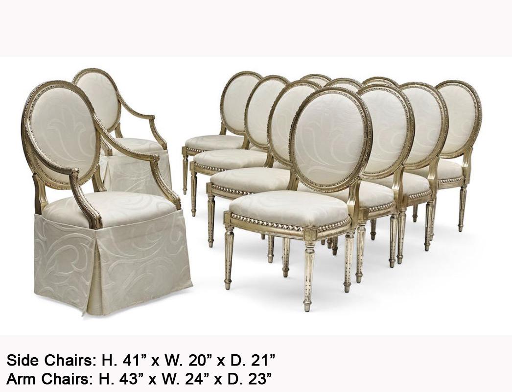 Impressive set of 12 French Louis XVI style silver leafed dining chairs. 
20th century. 
A set of 12 round-back chairs with a hand carved gadroon silver leaf frame, upholstered with a white fabric, all resting on four tapered fluted legs.