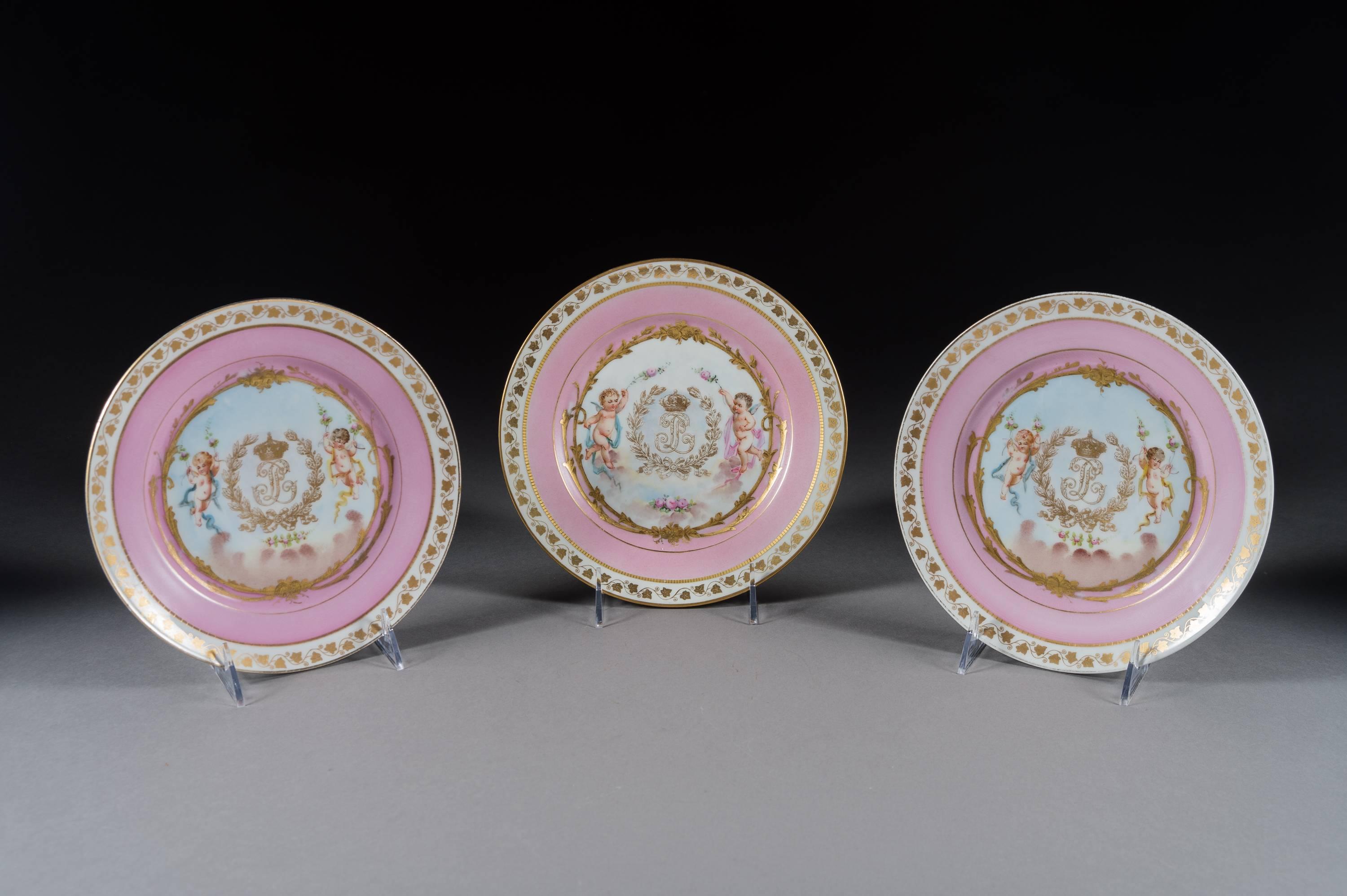 A very fine set of 12 French Sevres pink ground porcelain painted and jeweled plates. 

Each with a gold and pink border with a central painting depicting cherubs with a garland of flowers, with a gold royal coat of arms. 

Each signed with