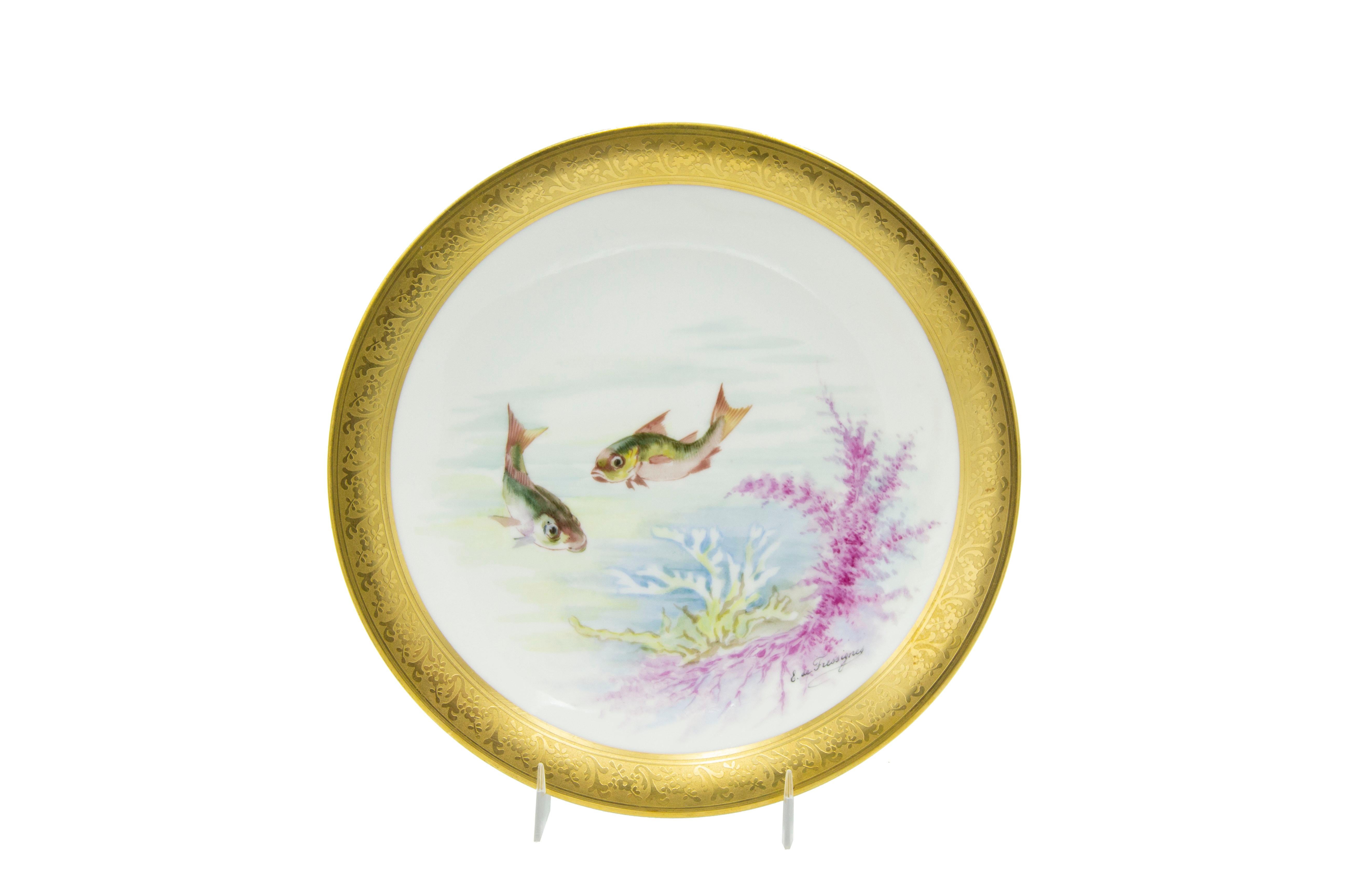 Set of 12 French Victorian-style (Early 20th Century) porcelain plates with gilt border and depicting fish, designed and signed E. de Fressignes (by Elite of Paris for Bawo & Dotter of New York)
