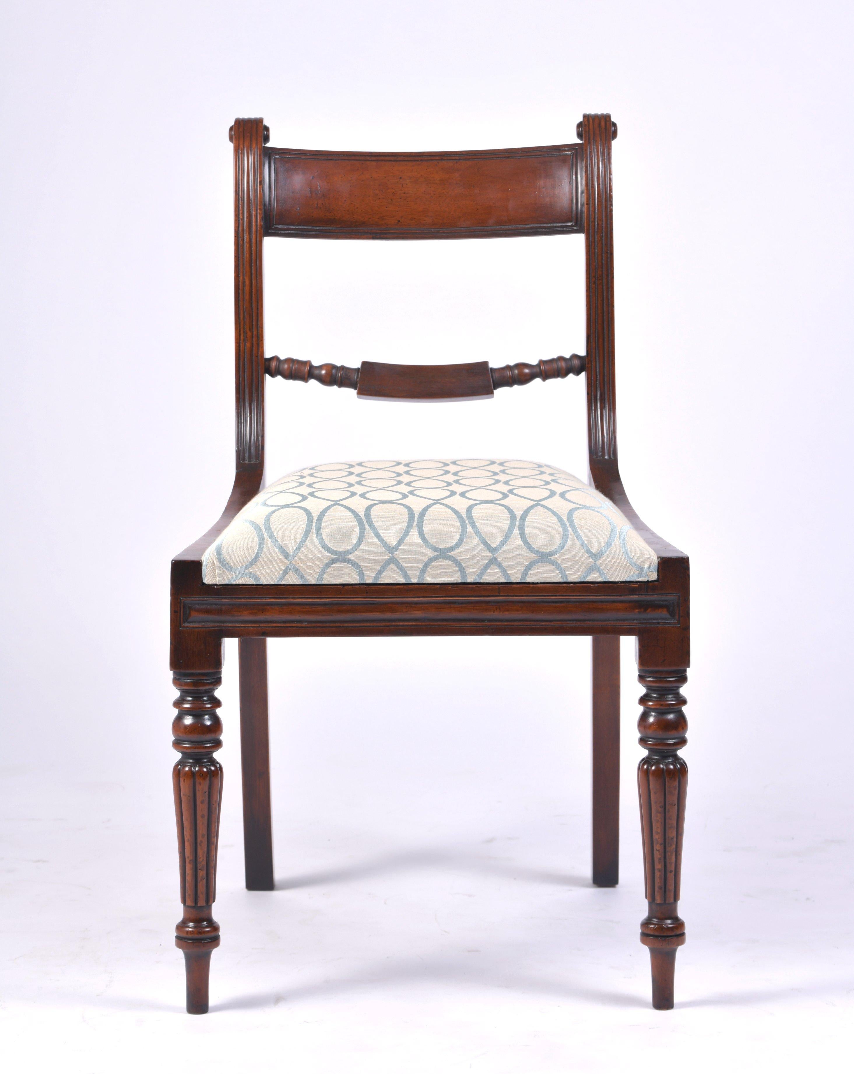 This superb and elegant set of 12 George VI style dining chairs feature 10 side chairs with 2 carvers. The chairs have turned front and swept back legs with a powder blue patterned upholstered seat. Each side chair measures 19 ¼ - 49 cm wide, 19 in