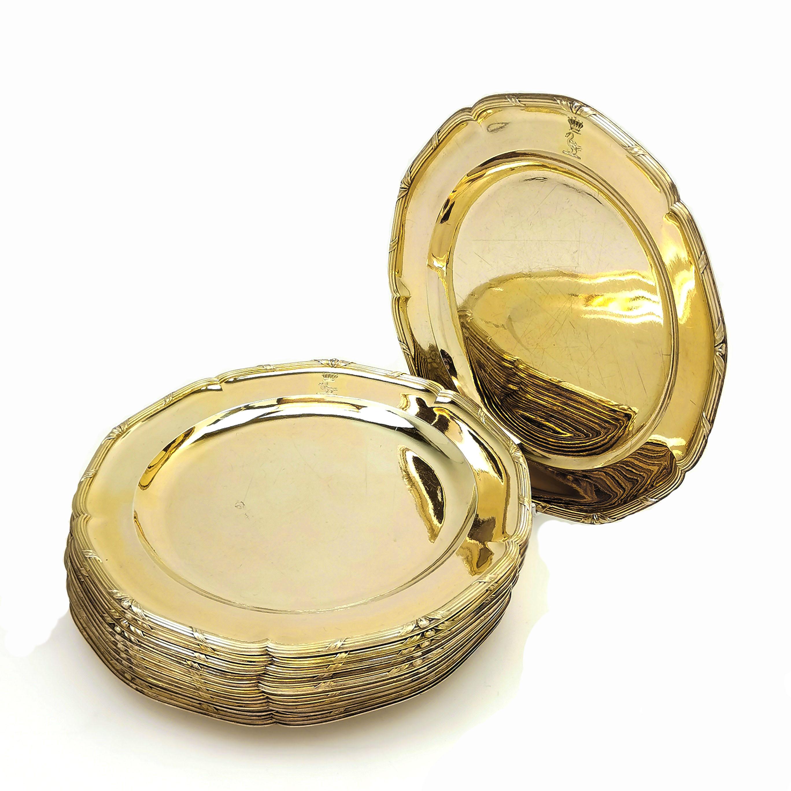 A magnificent set of 12 George III Sterling Silver Gilt Dinner Plates. These shaped round Plates have an elegant ribbon and reed border and each has an engraved crest on the rim. The set had a gilded finish.

Made in London in 1787 by John Wakelin &